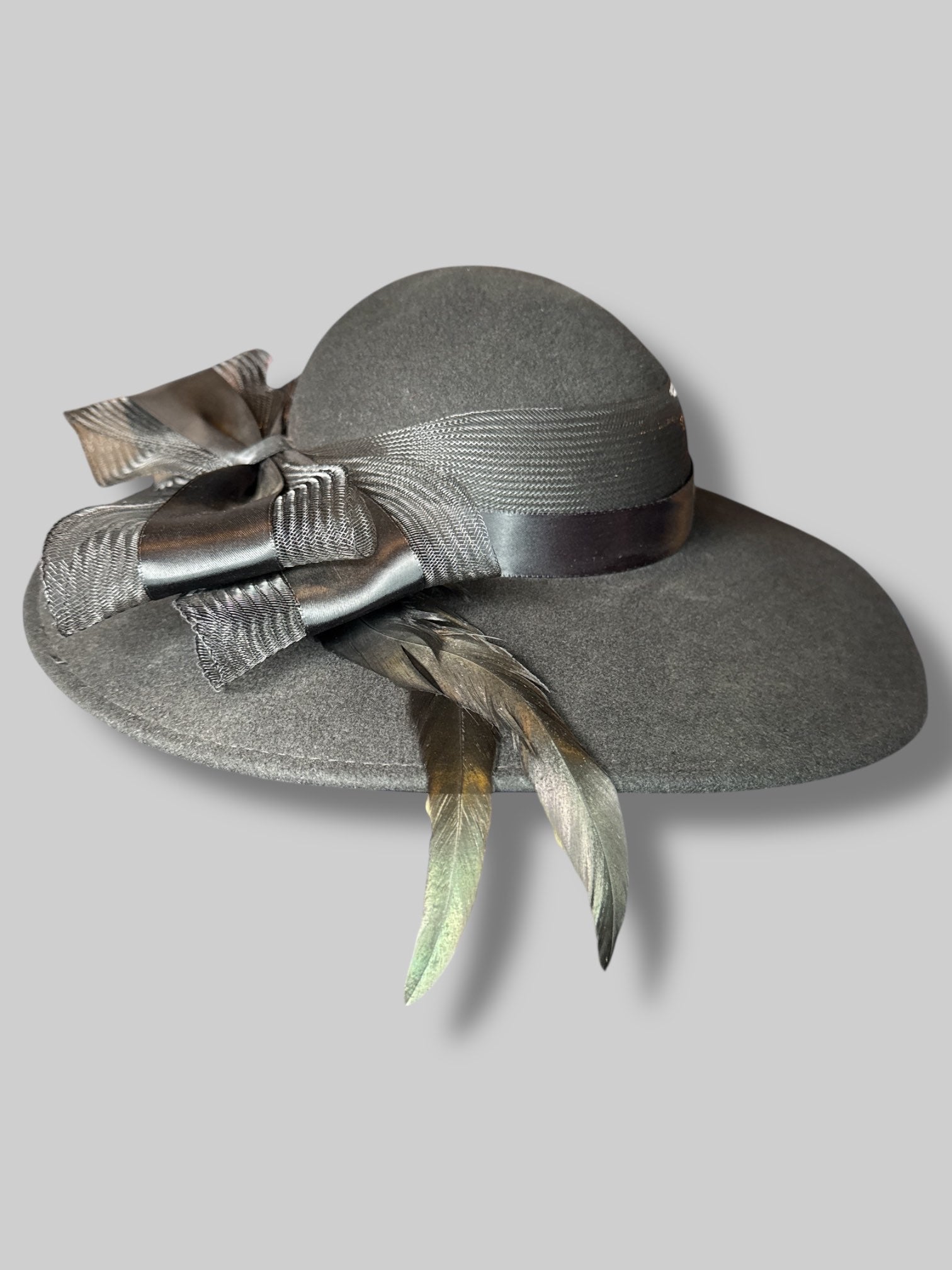 Black wide brim hat with mesh, netting and ribbon bow, and iridescent feathers