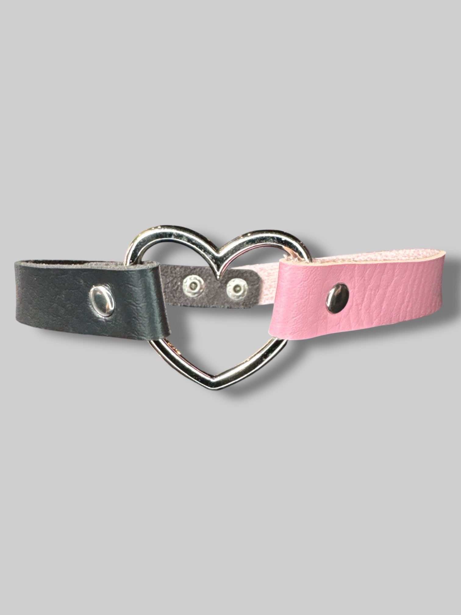 Black and pink leather choker with heart ring in middle, and snap button closure