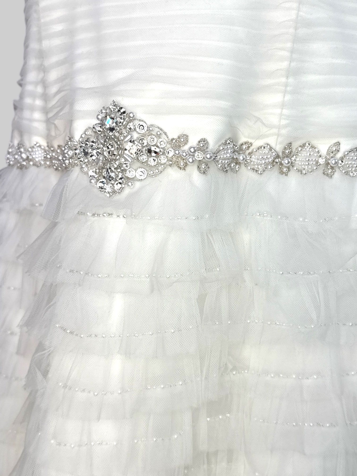 L David’s Bridal white wedding reception type dress with tule ruffles that become sheer at the bottom, pearl and stone belt, boning, and ruched bodice