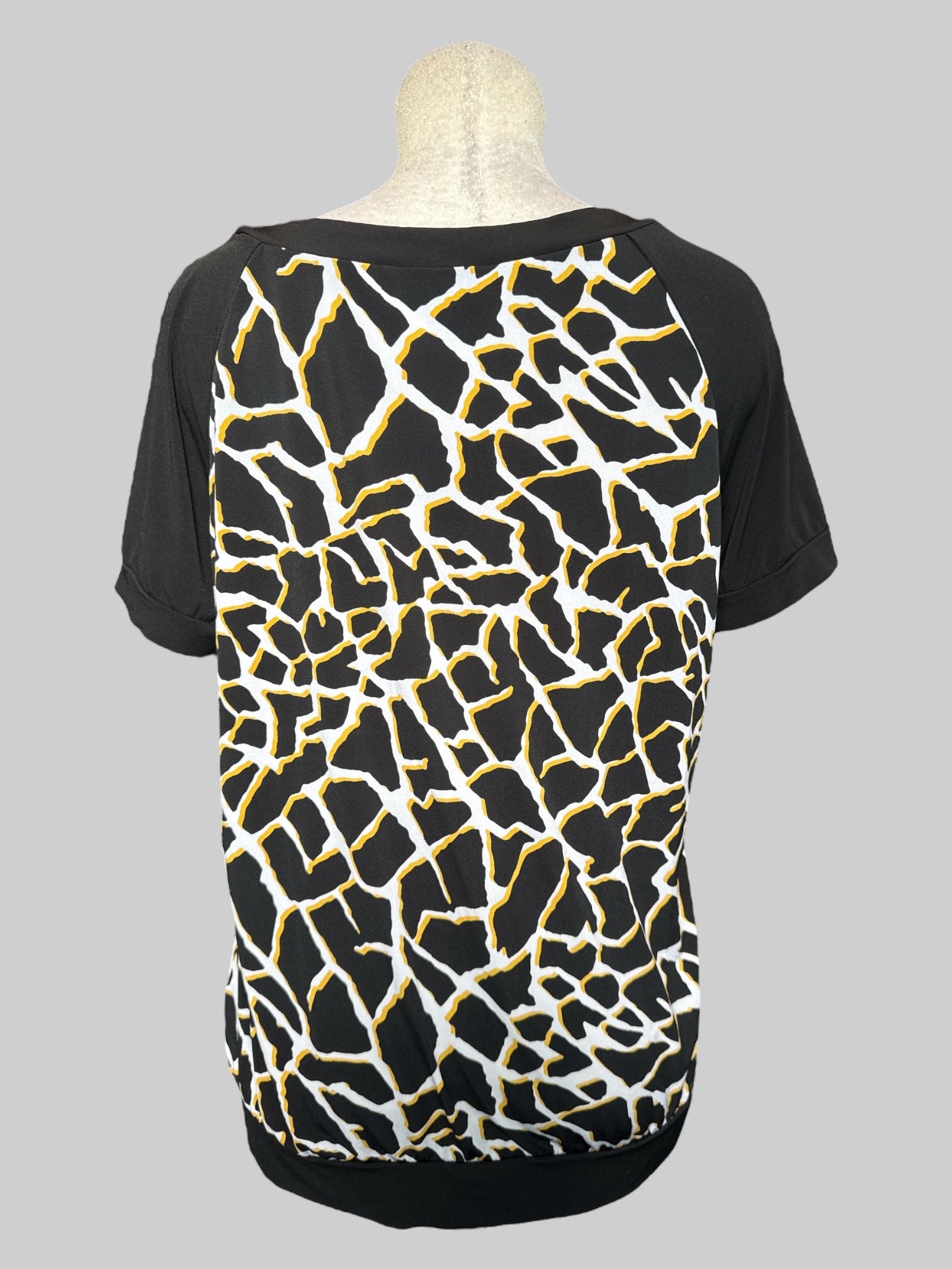 1X black, white, and yellow top with geometric pattern