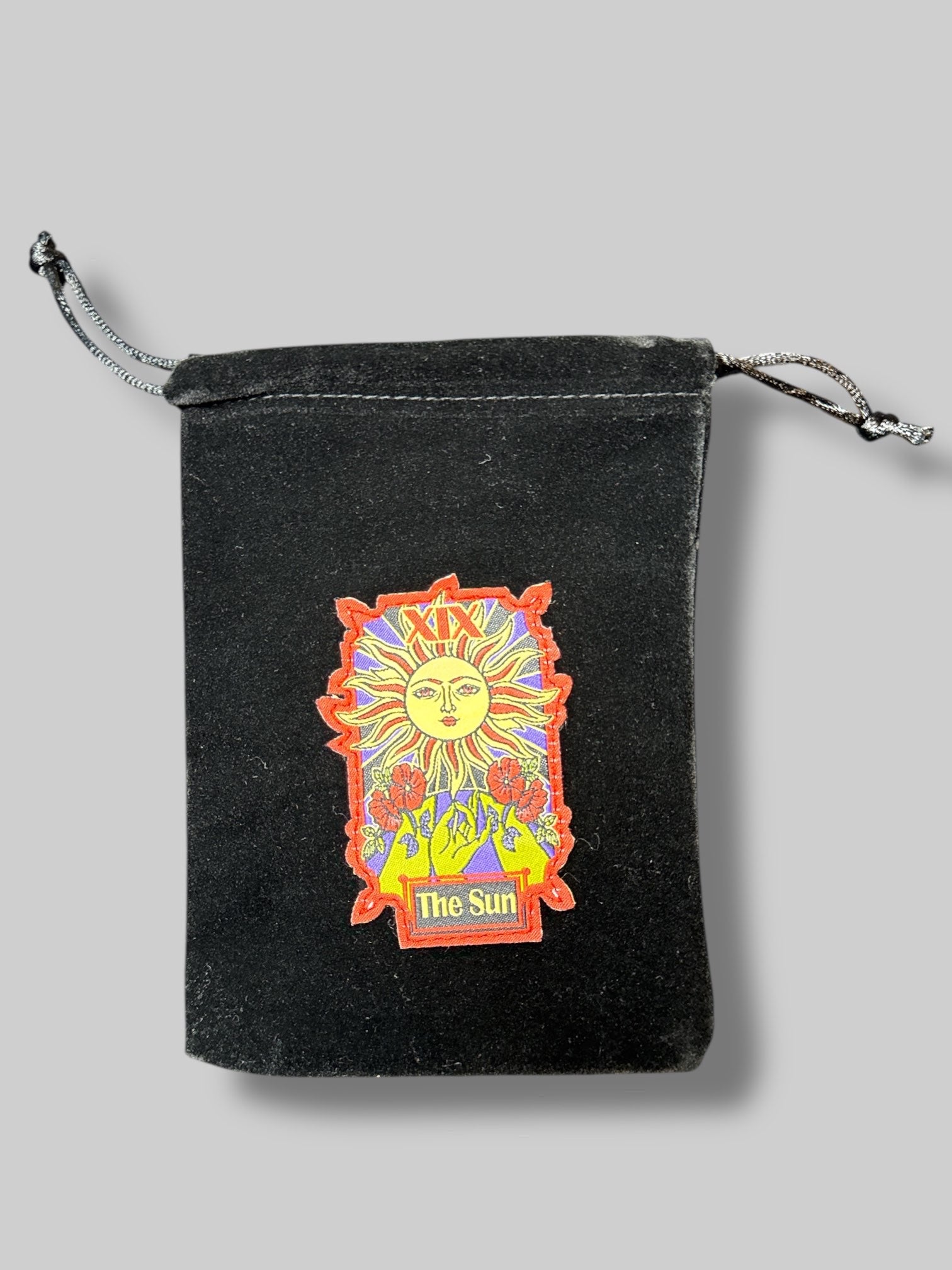 Black velvet tarot pouch with the sun patch