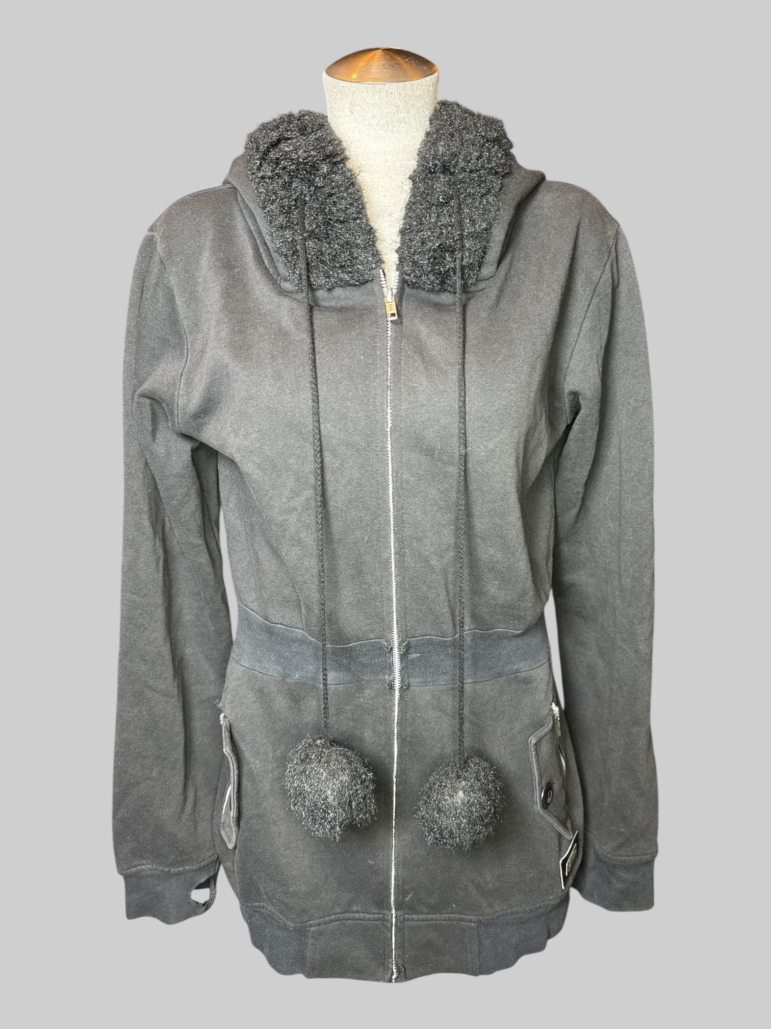 L black, long sleeve, zip up hoodie with zipper pockets, large fuzzy pom-poms on end of drawstring, and fuzzy hood