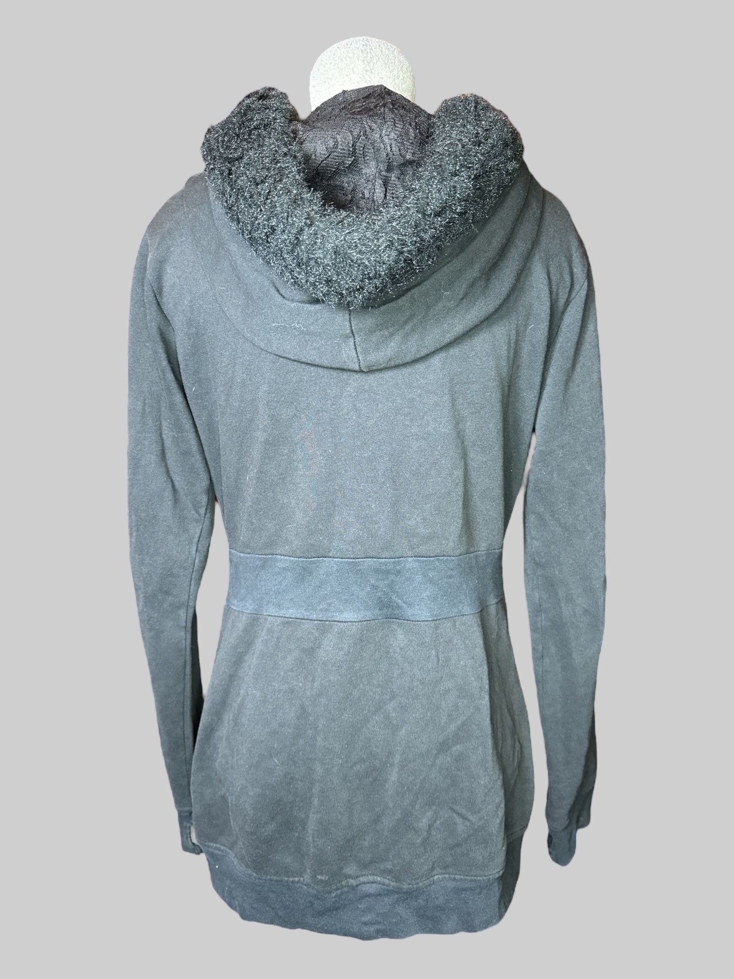 L black, long sleeve, zip up hoodie with zipper pockets, large fuzzy pom-poms on end of drawstring, and fuzzy hood