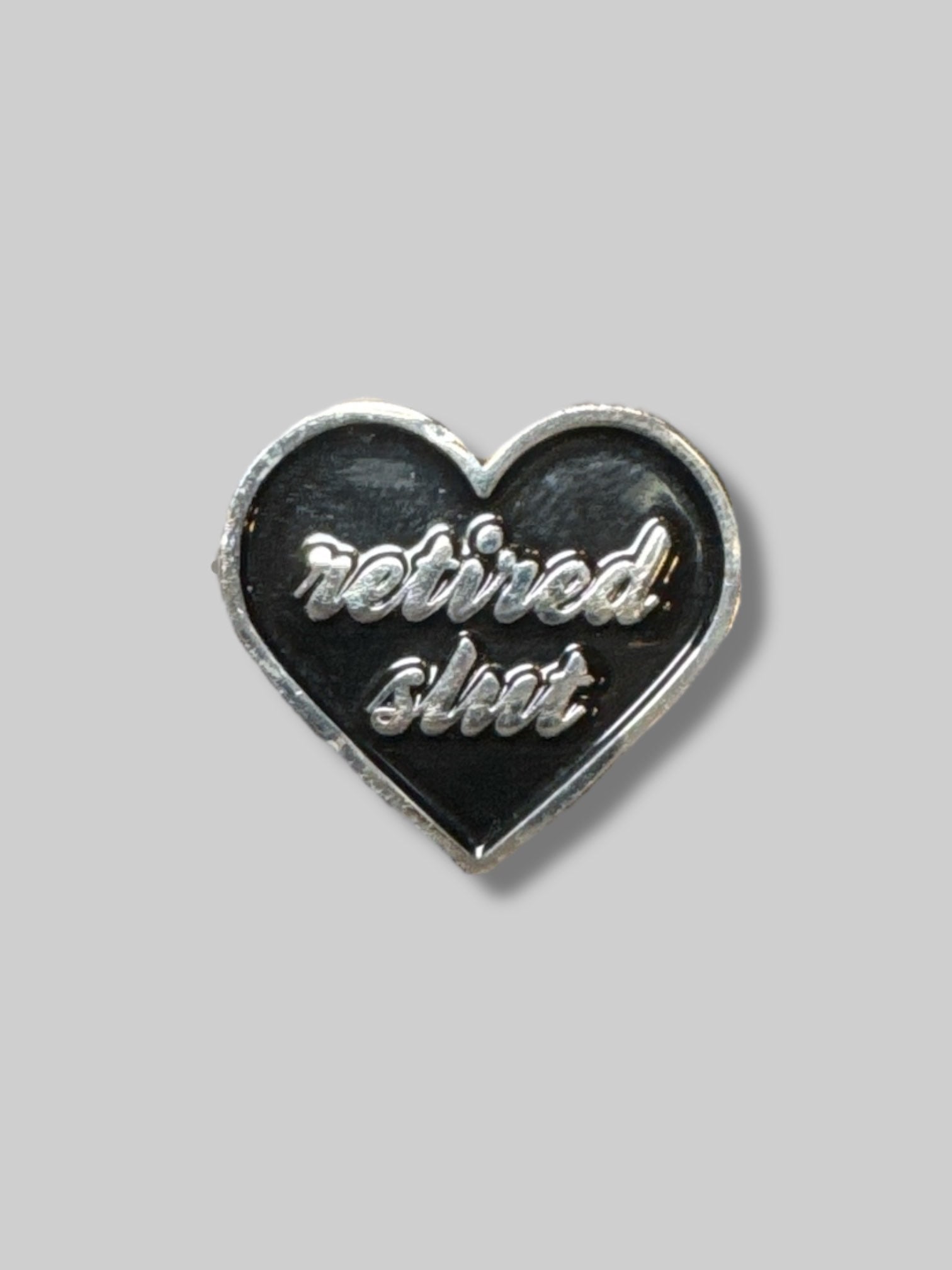 “Retired Slut” black enamel heart shaped pin