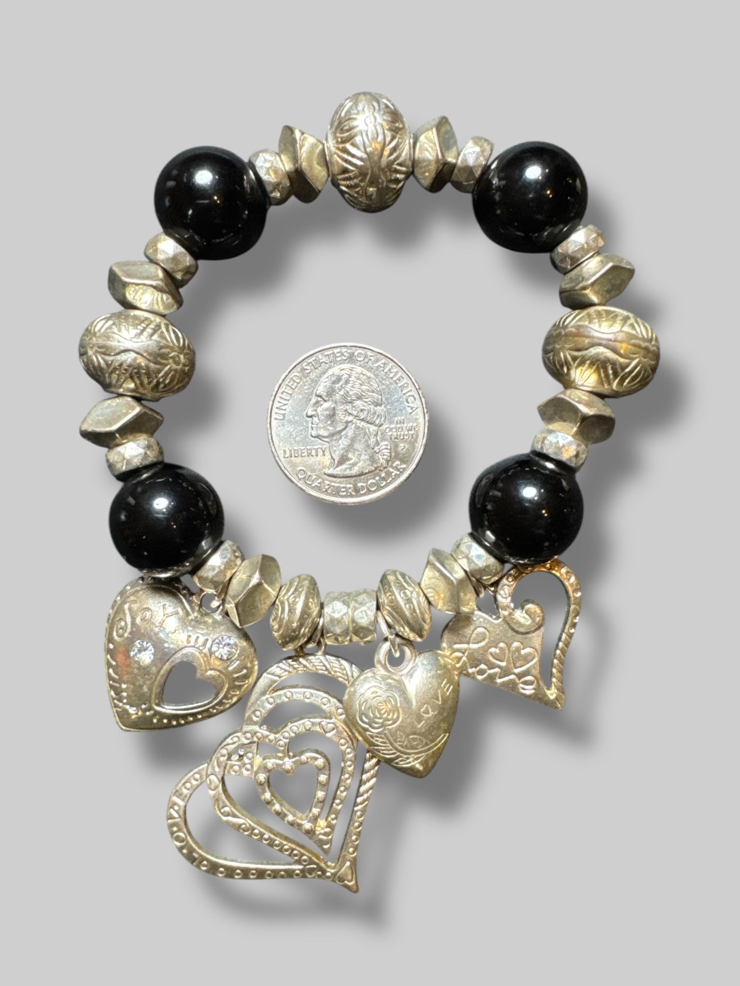 Black and silver tone beaded stretchy bracelet with multiple heart charms