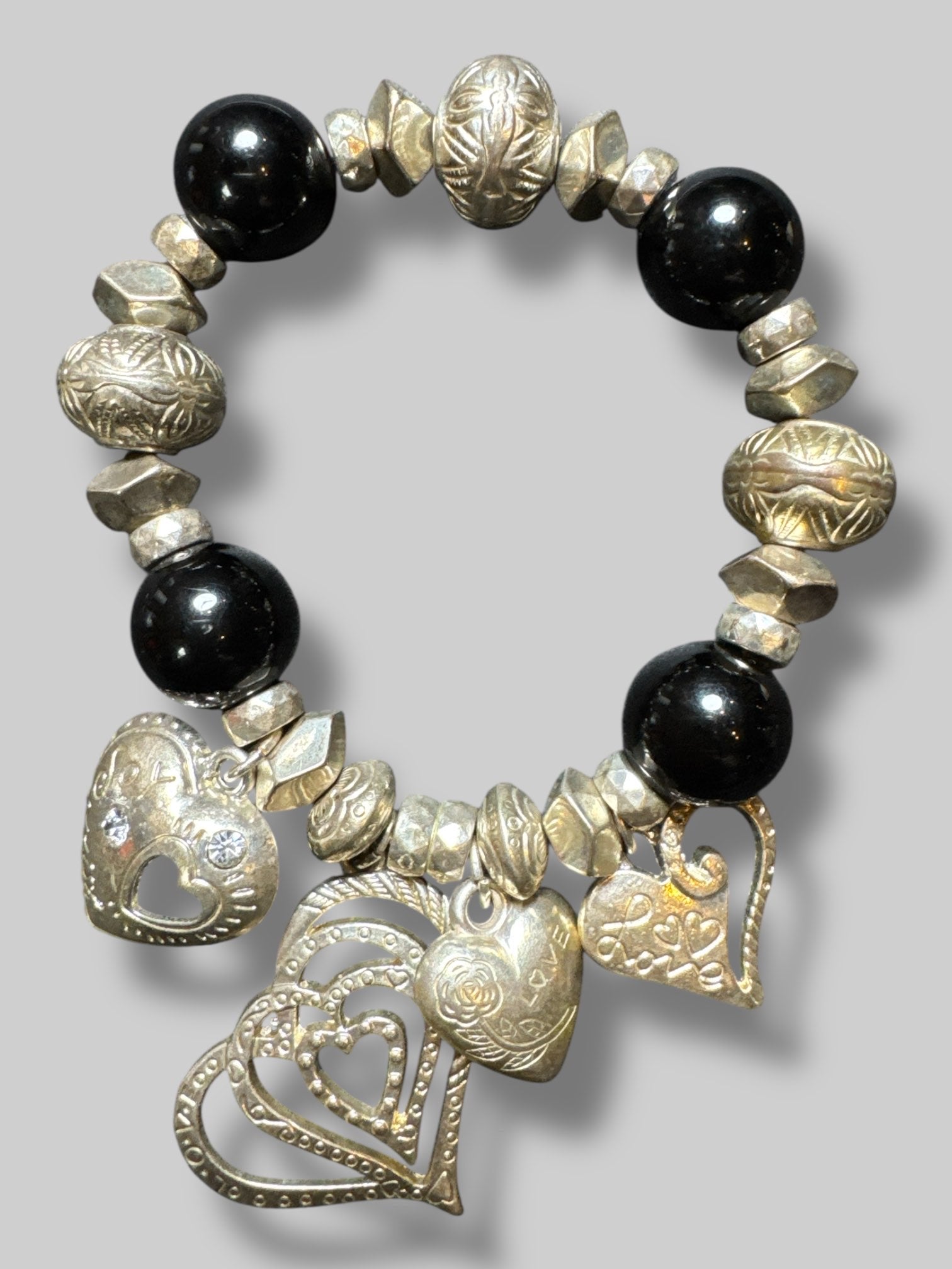 Black and silver tone beaded stretchy bracelet with multiple heart charms