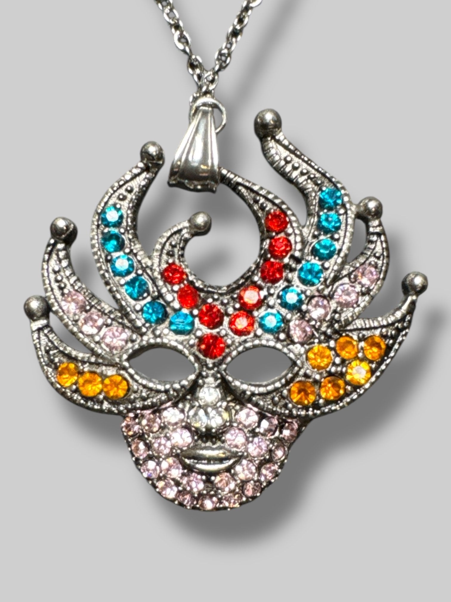 Silver tone multicolor rhinestone mask pendant with 15.5” chain