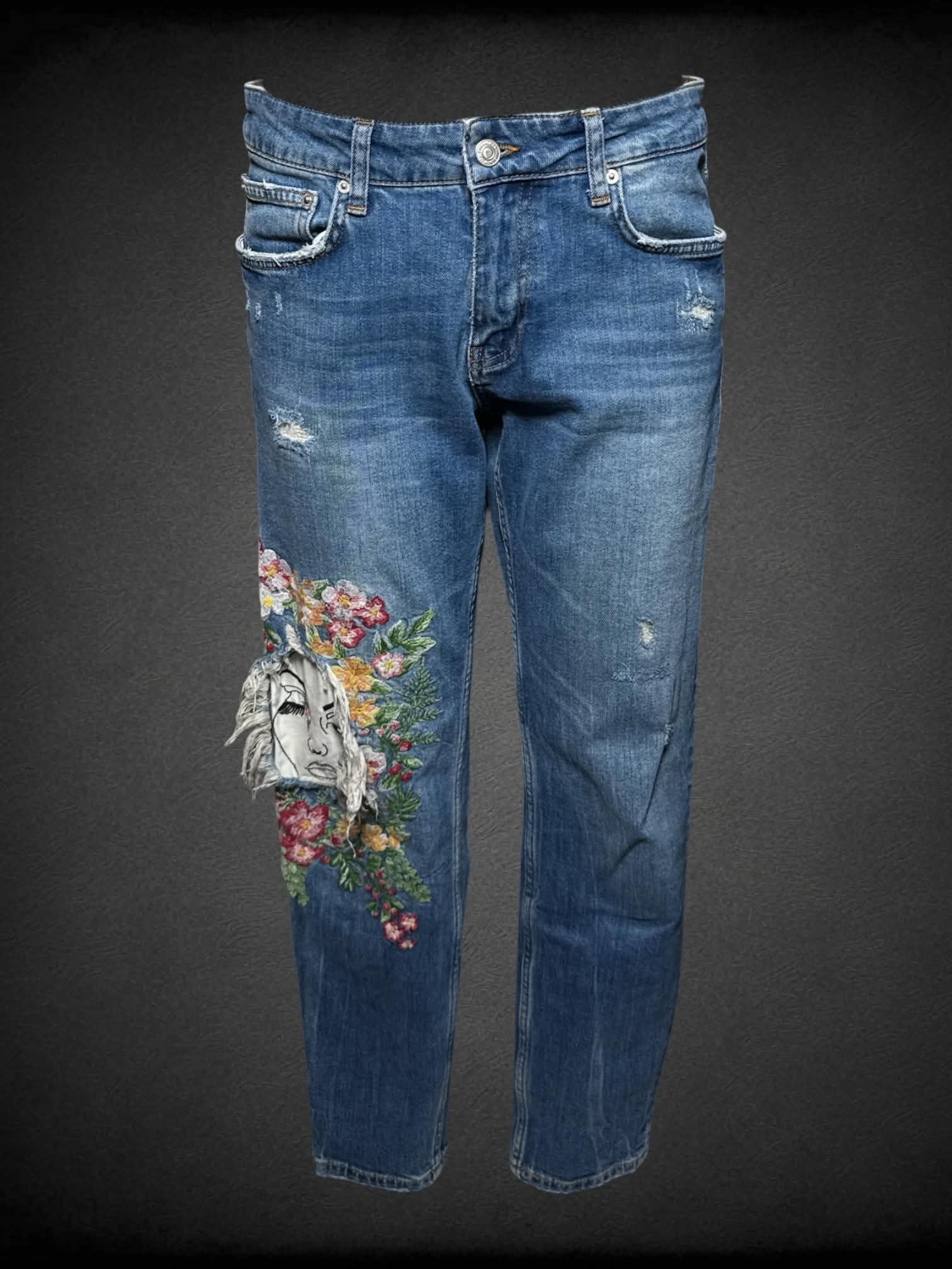 L Zara blue distressed jeans with embroidered floral design, and cutout of a face on knee