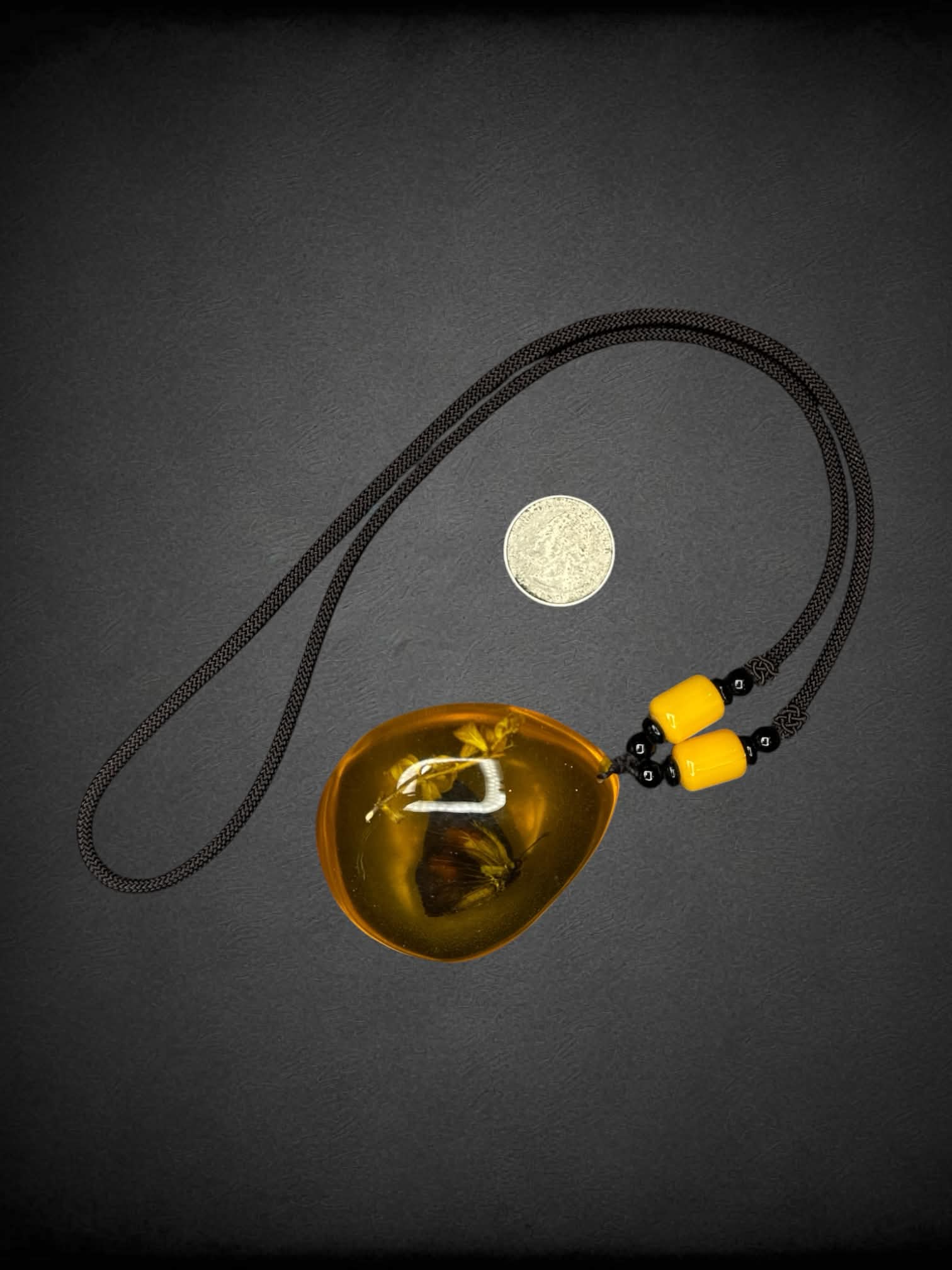 Black chord necklace with butterfly amber charm