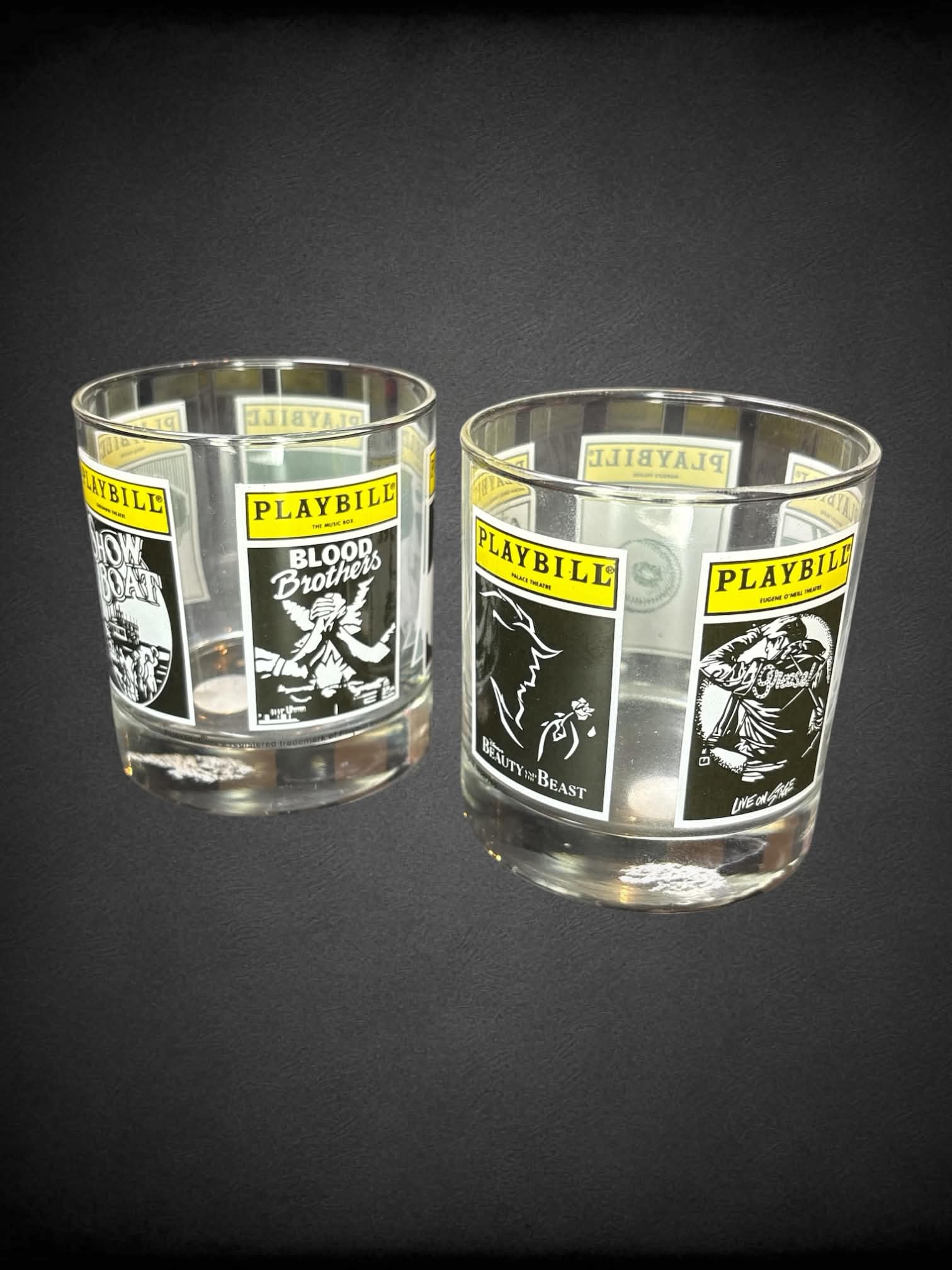Playbill set-of-two drinking glasses with different “Playbill” posters wrapping around glass