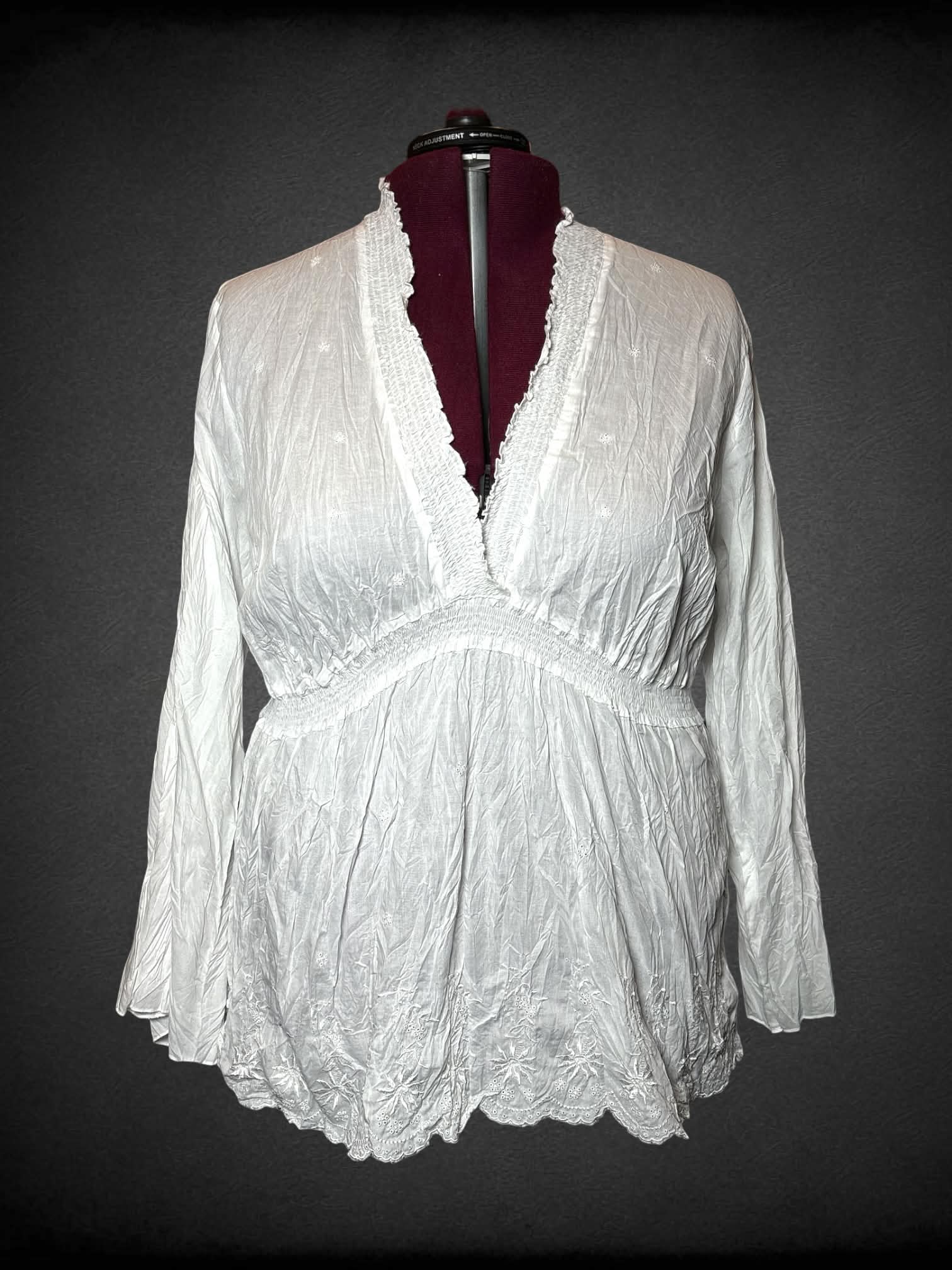 3X Sunny Leigh white long-sleeve blouse with empire waist seem, bell sleeves, and embroidered flower hem