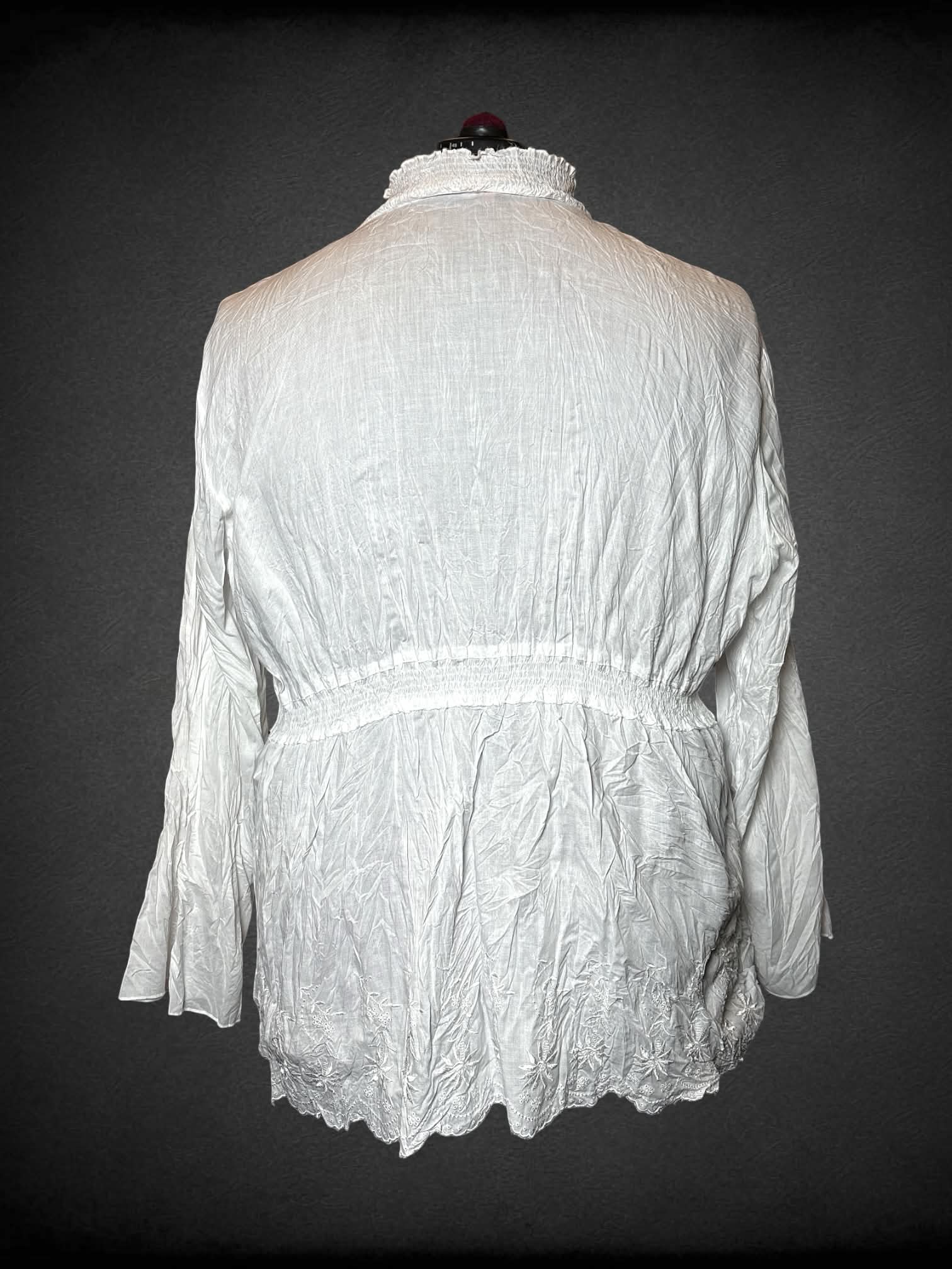 3X Sunny Leigh white long-sleeve blouse with empire waist seem, bell sleeves, and embroidered flower hem