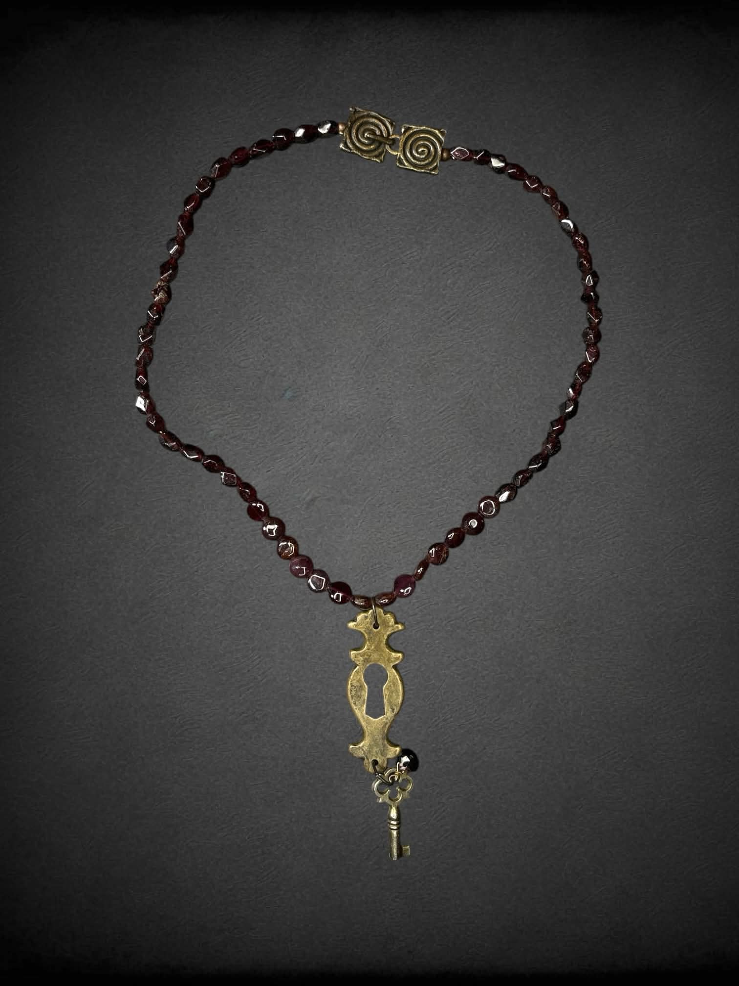 Garnet beaded necklace with keyhole & key charm, and metallic spiral clasp