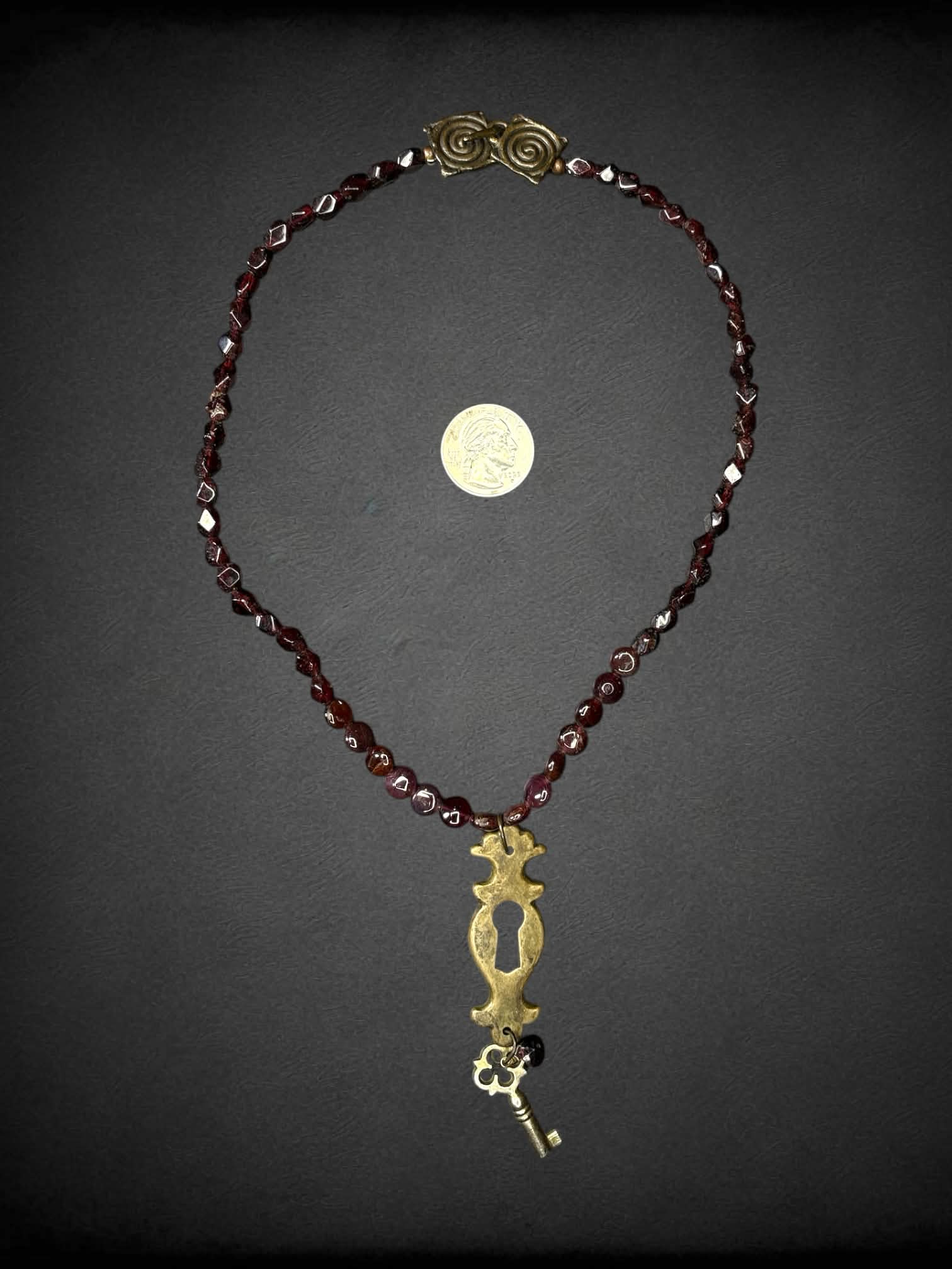 Garnet beaded necklace with keyhole & key charm, and metallic spiral clasp