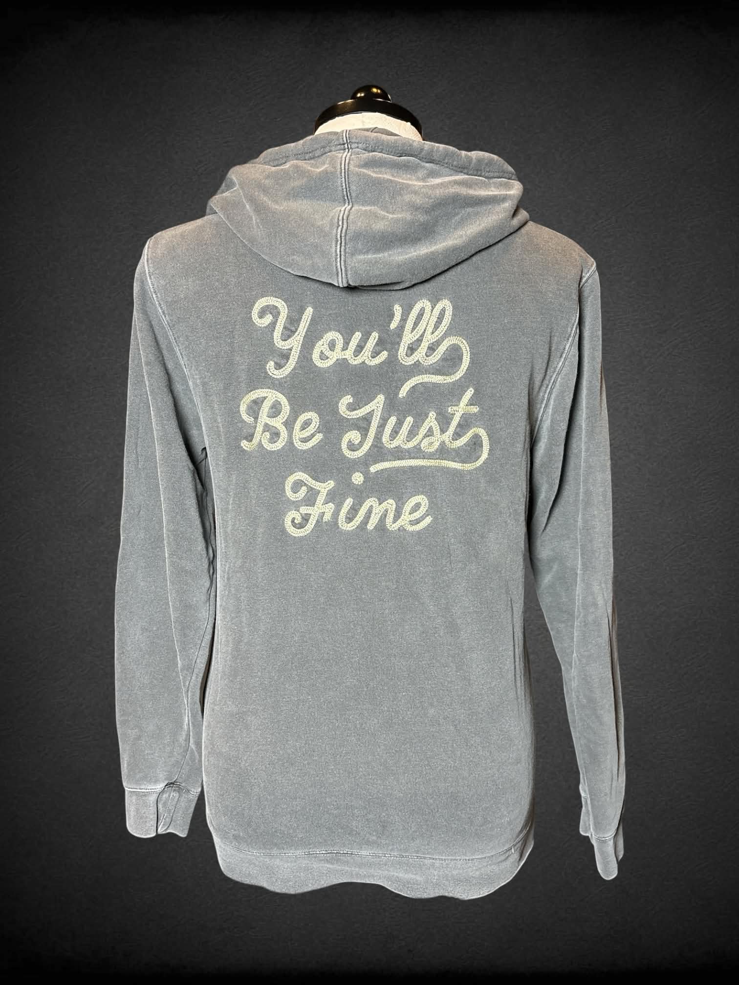 1X Independent Trading Company grey pullover hoodie with embroidered “Movements” on front and “You’ll Be Just Fine” writing on back