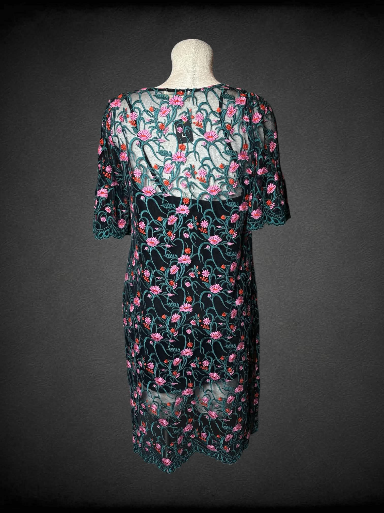 L Moulinette Soeurs black short dress with green mesh overlayer, and embroidered flower pattern
