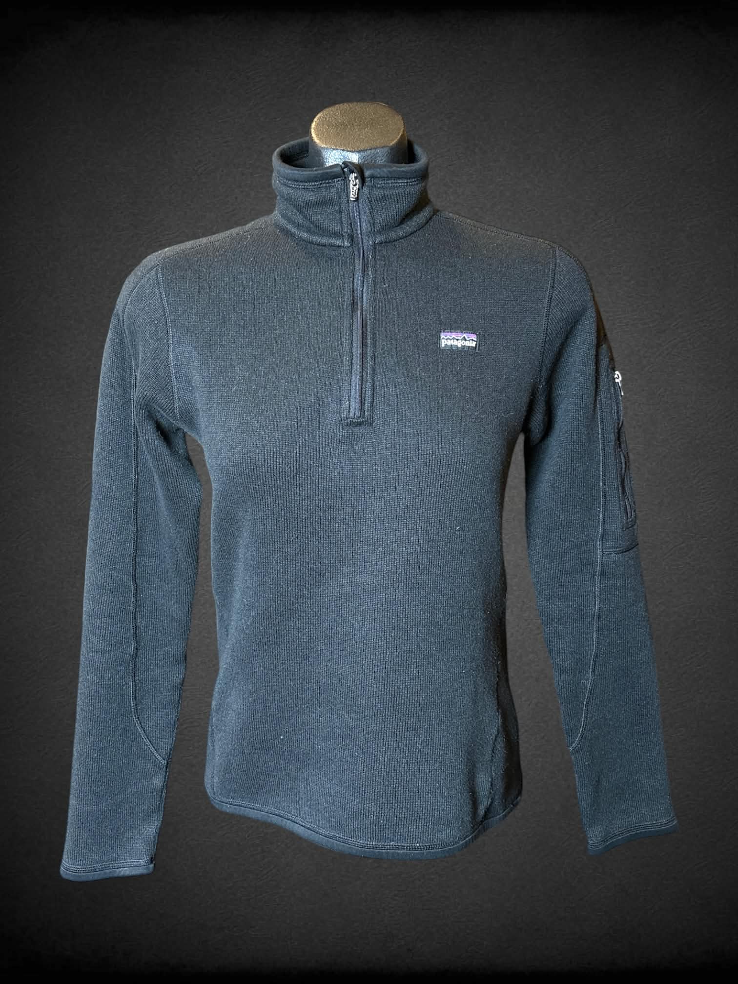 M Patagonia black turtleneck jacket with zipper on front, and zipper pocket on sleeve