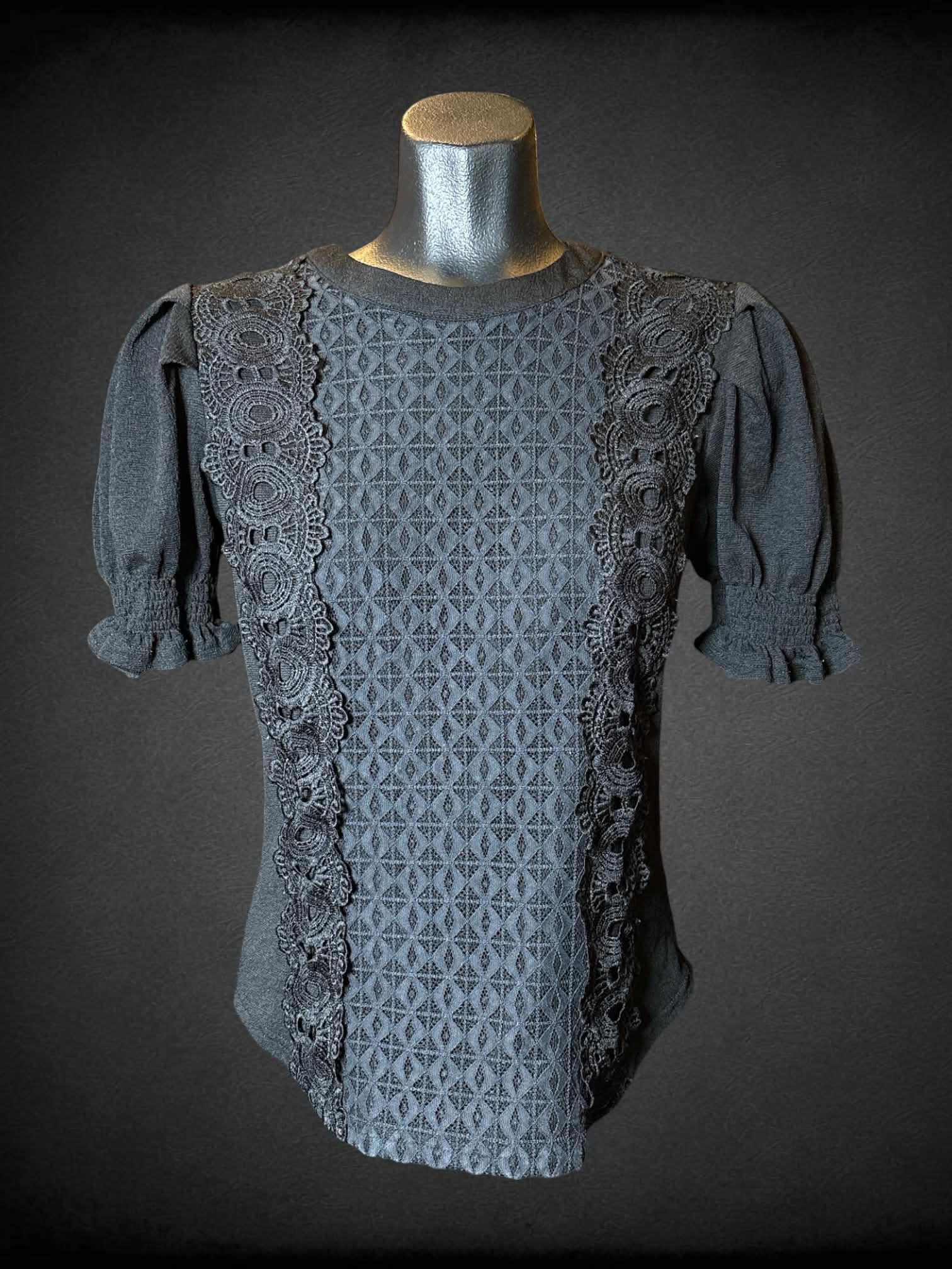 M Mine black blouse with lace and embroidery design on front, buttons on back, and ruffle sleeves