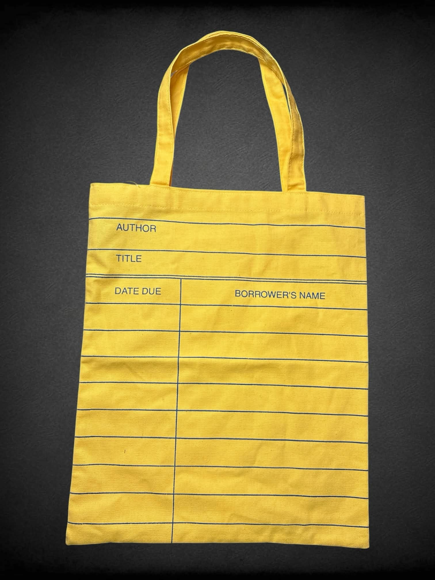 Out of Print NWT yellow tote bag with library book due date design