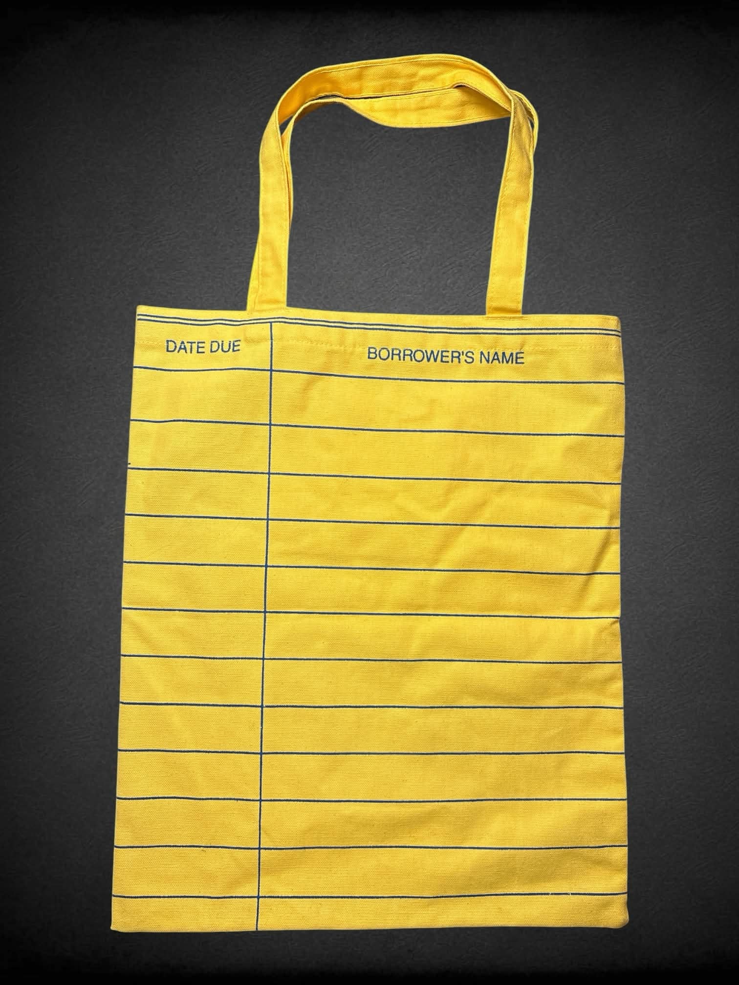 Out of Print NWT yellow tote bag with library book due date design