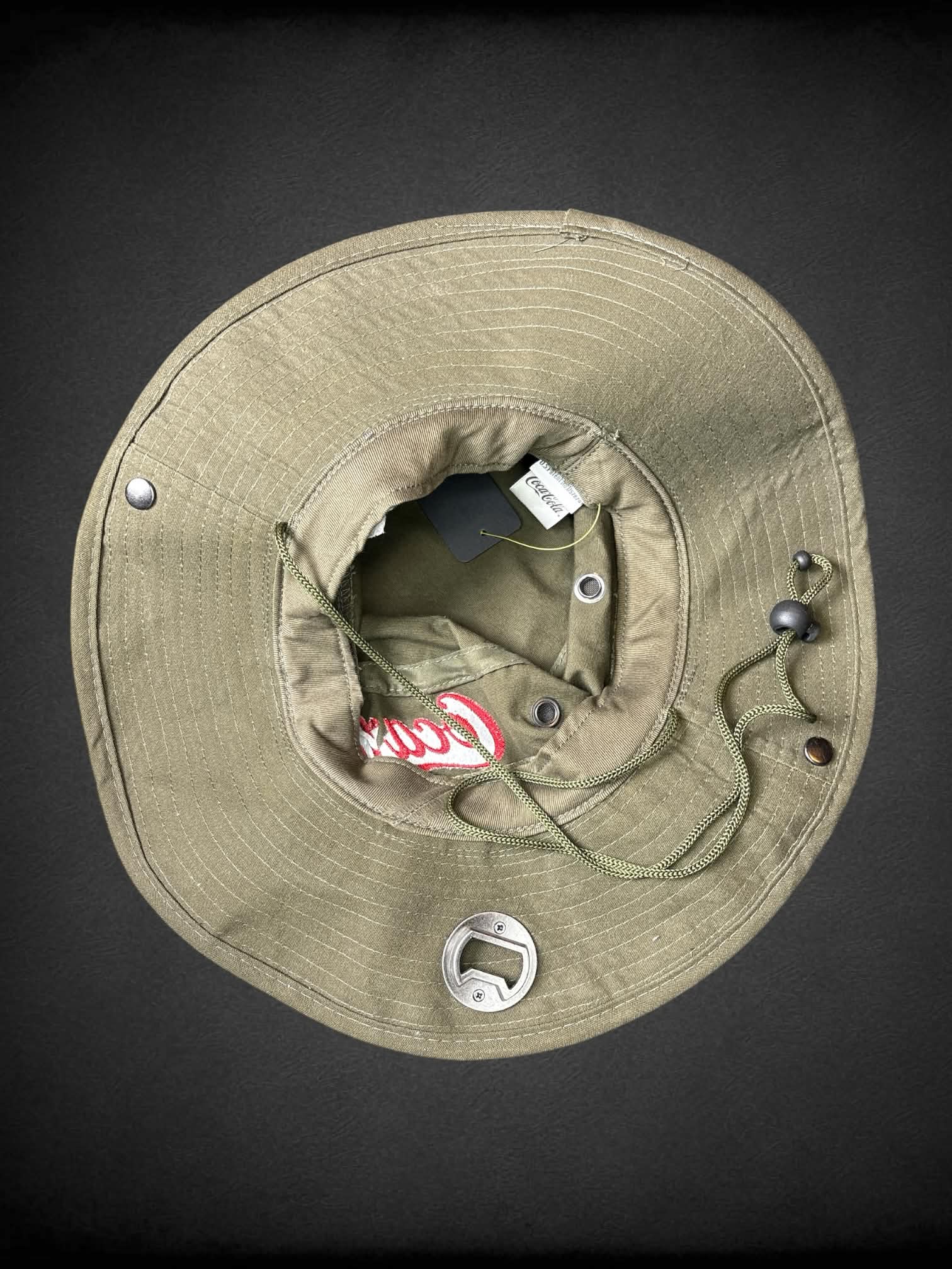 Coco Cola army green boonie bucket hat with metal bottle opener on brim, and adjustable chin strap