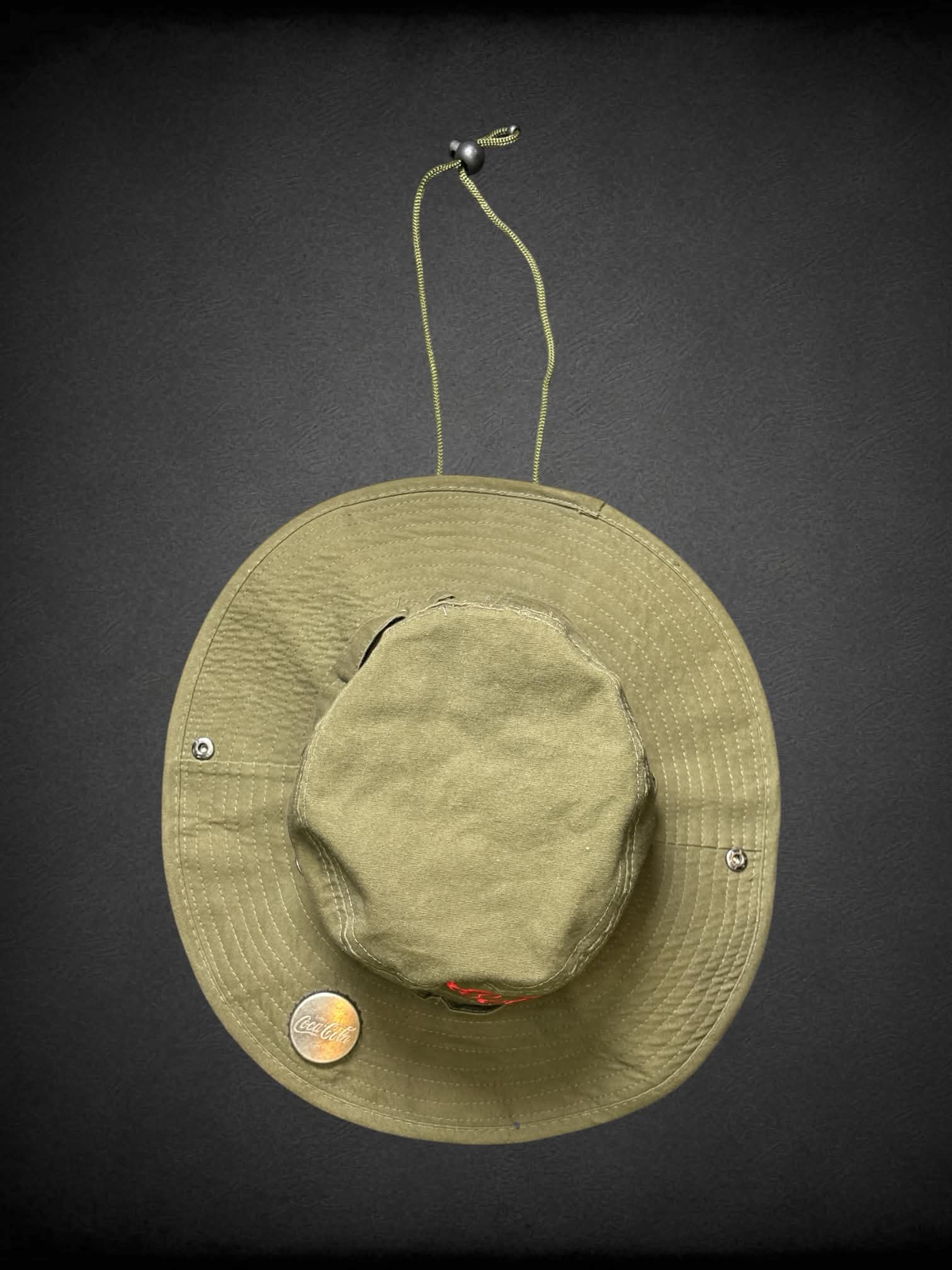Coco Cola army green boonie bucket hat with metal bottle opener on brim, and adjustable chin strap
