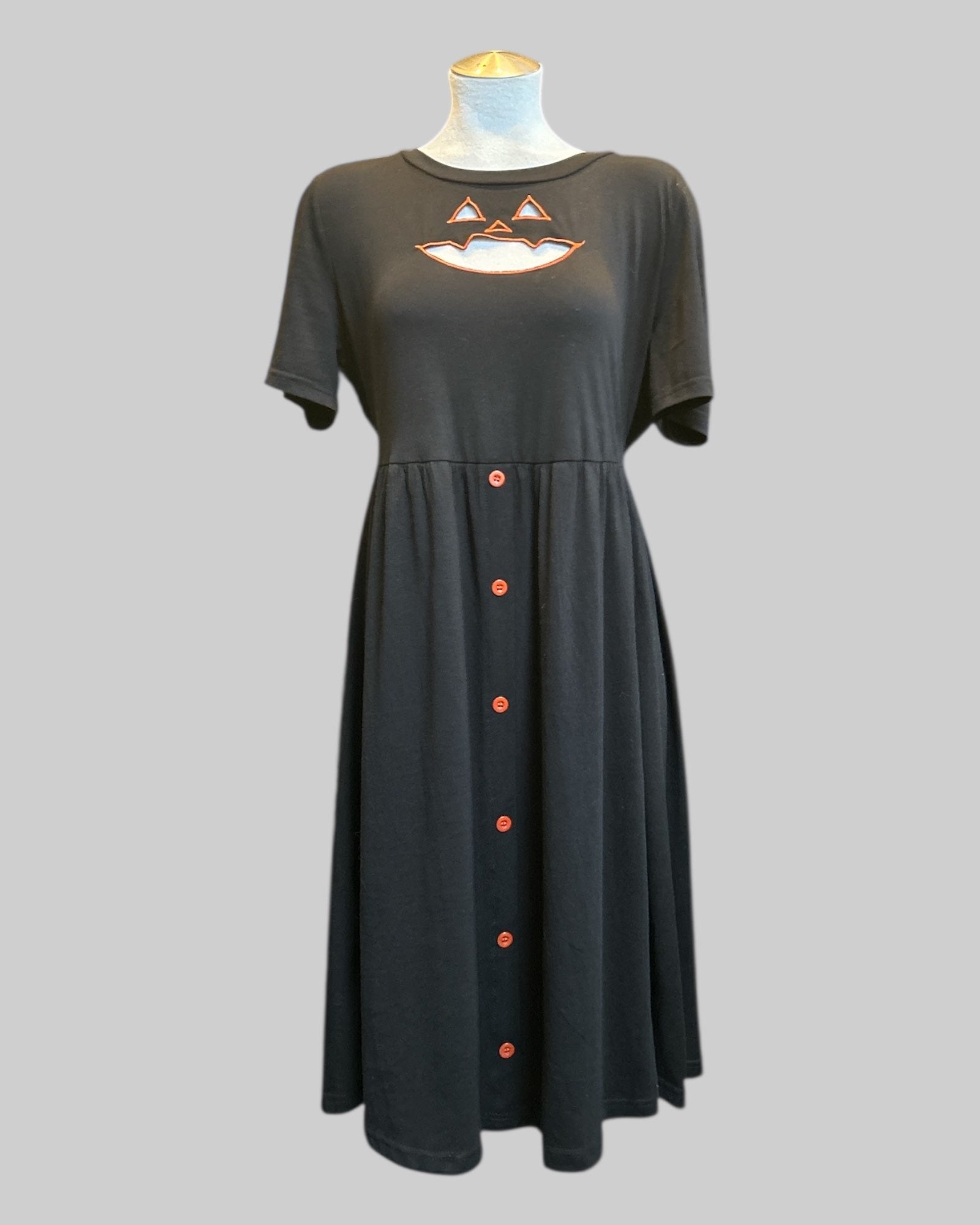 L black stretchy and flowy dress with jack o lantern chest cutout, buttons, and pockets