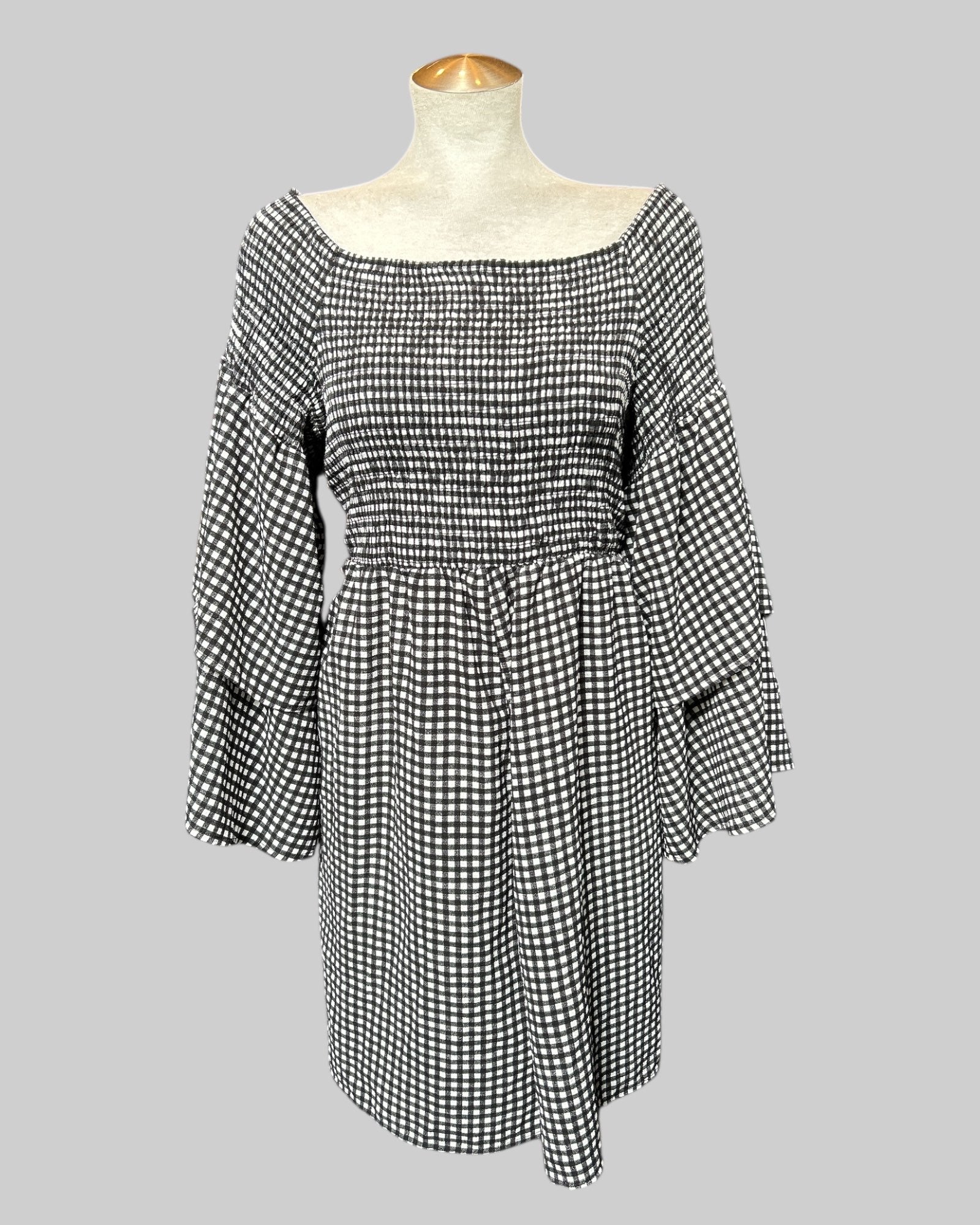3x black and white gingham pattern romper with shirred chest and back, and flowy tier sleeves