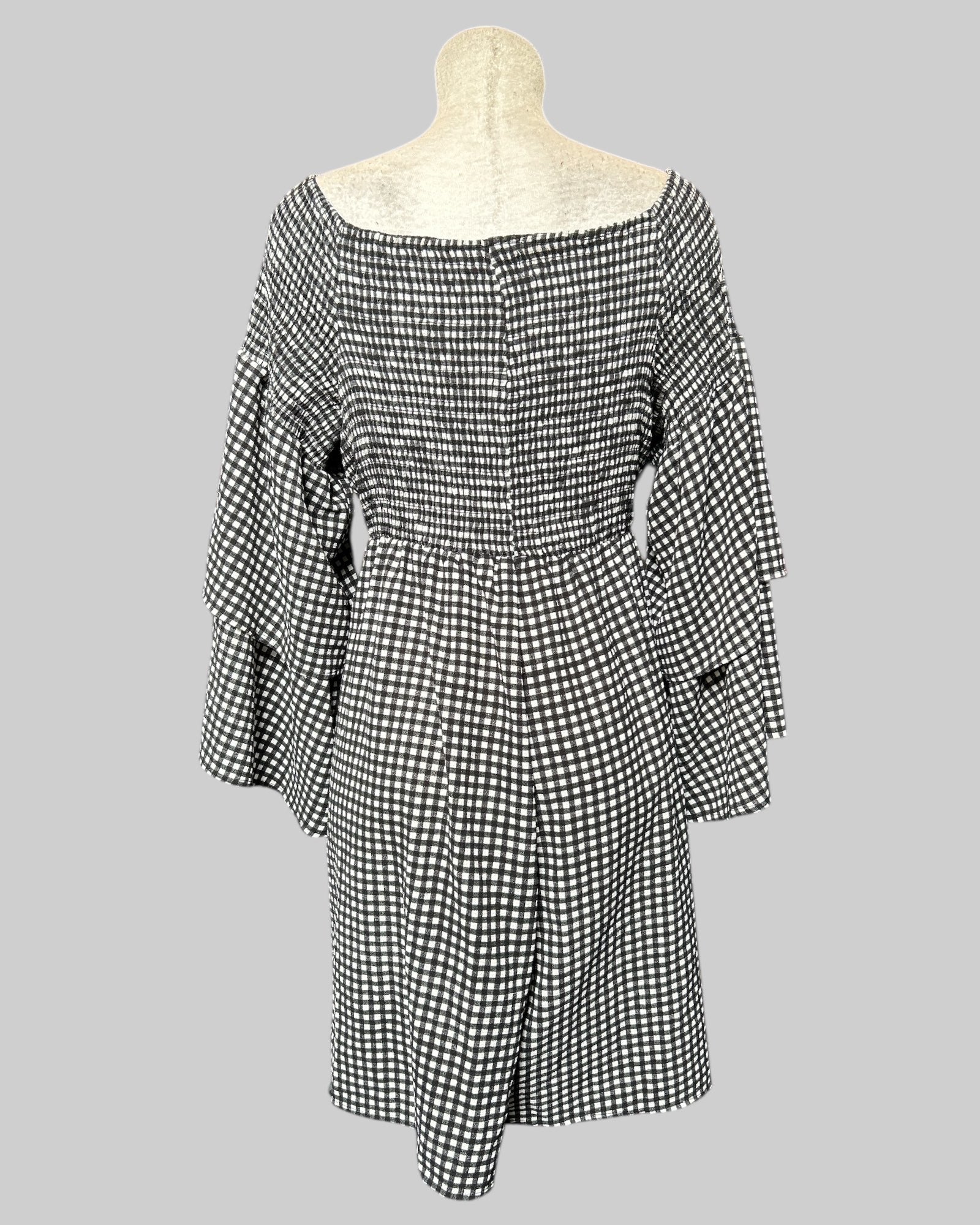 3x black and white gingham pattern romper with shirred chest and back, and flowy tier sleeves