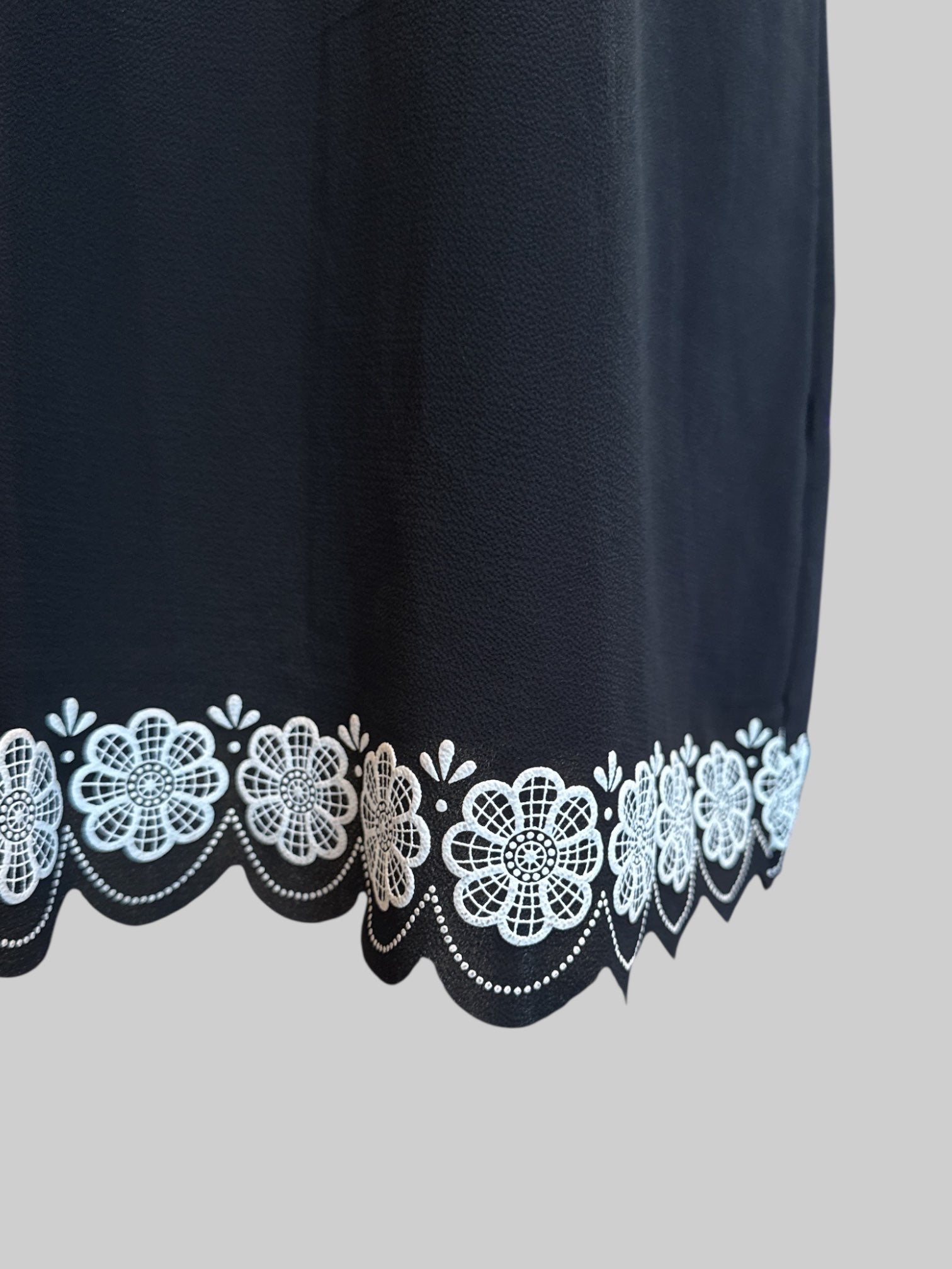 L black shift mini dress with floral details and scalloped hem