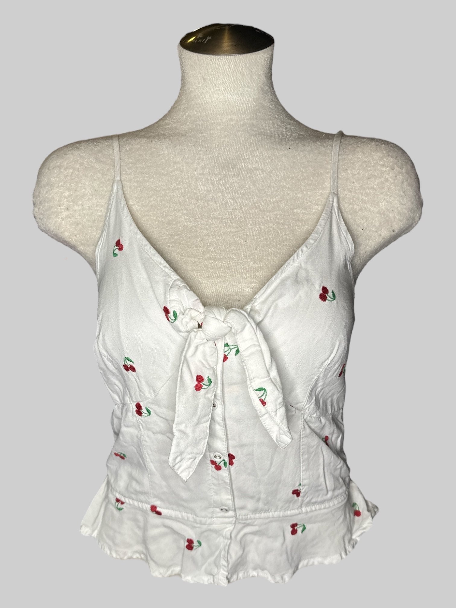 L White sleeveless top with cherry pattern with tie in front and shirred back