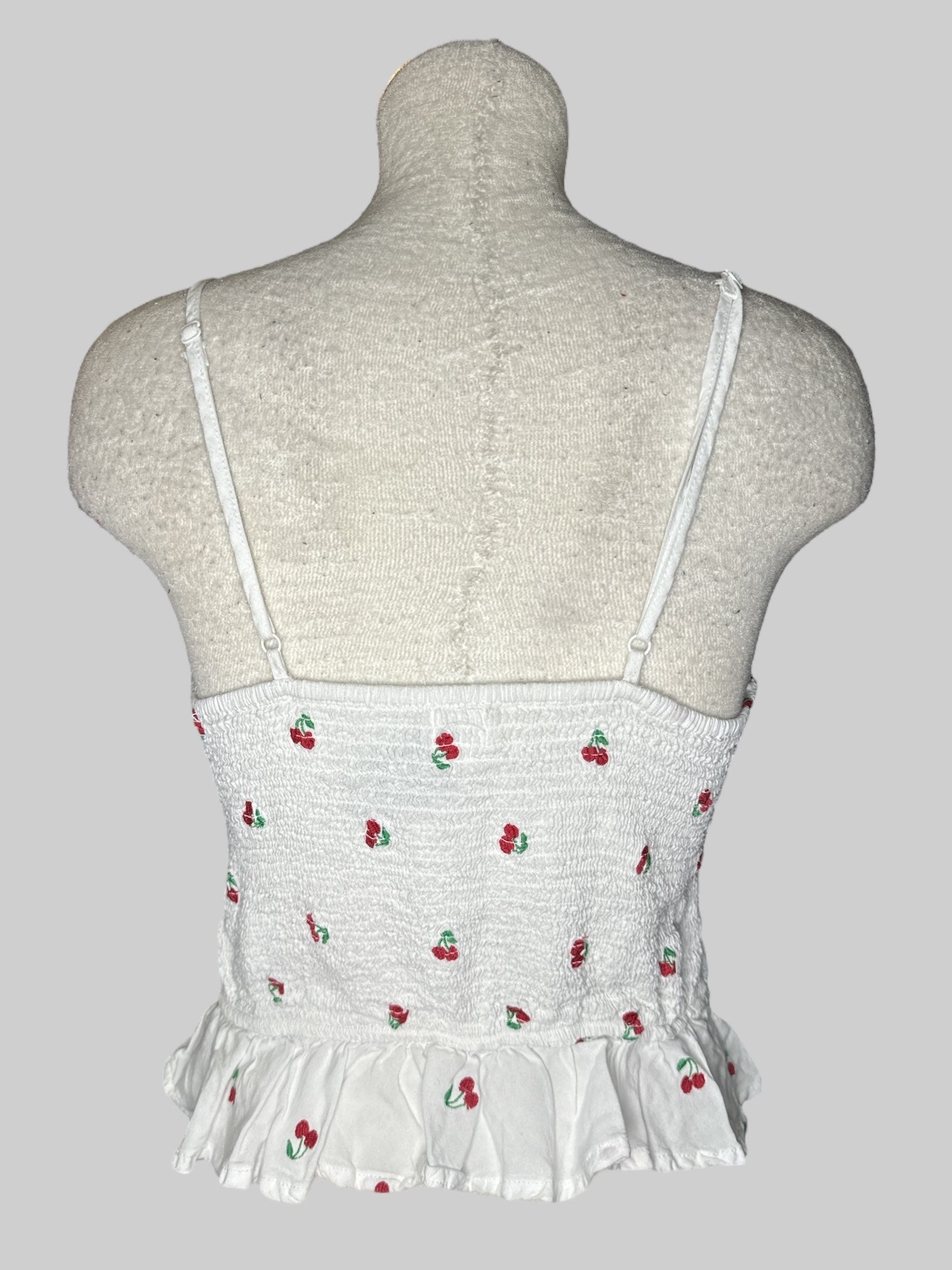L White sleeveless top with cherry pattern with tie in front and shirred back