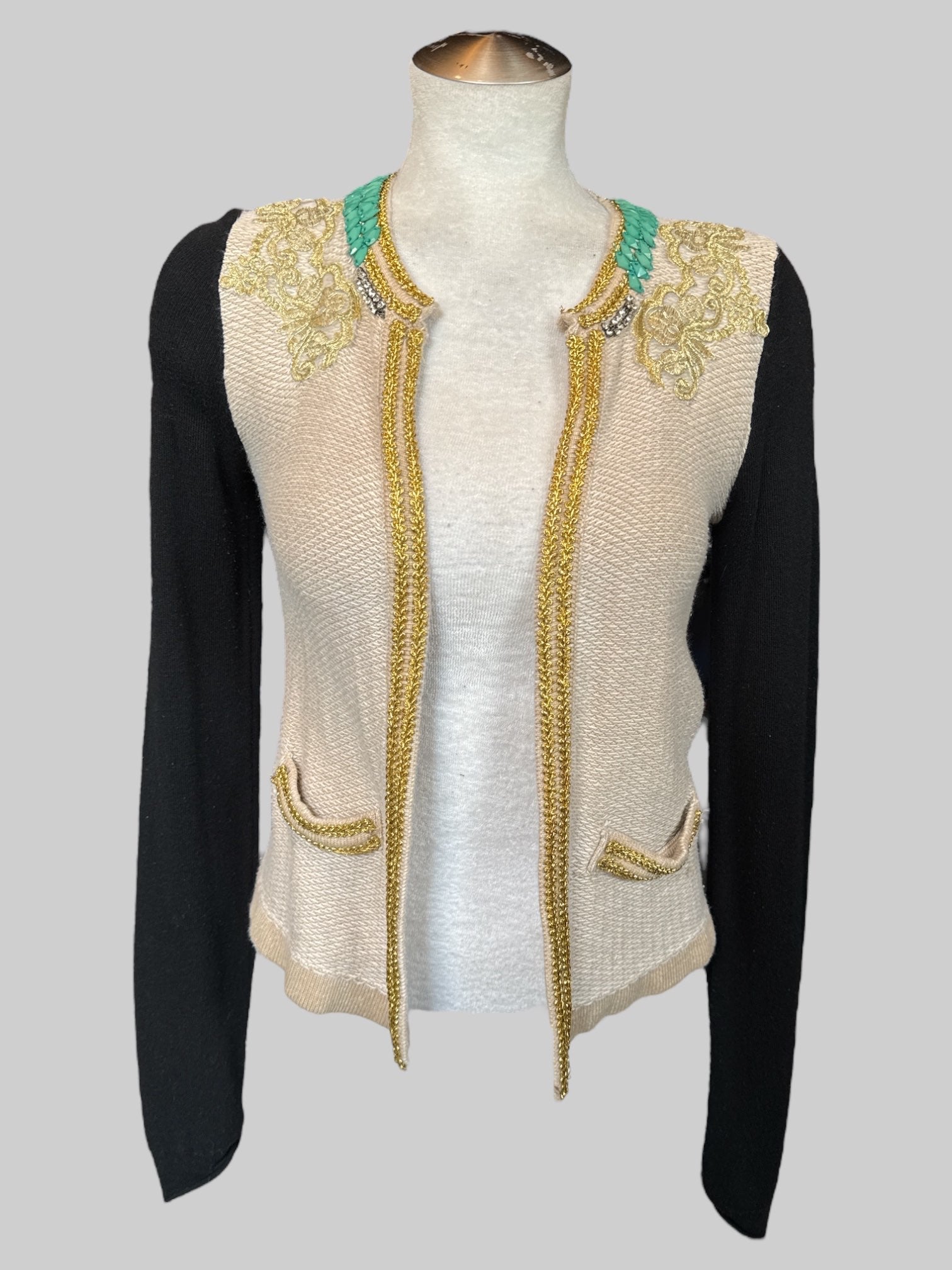 S cream cardigan with black sleeves, gold details, beads, and faux pockets