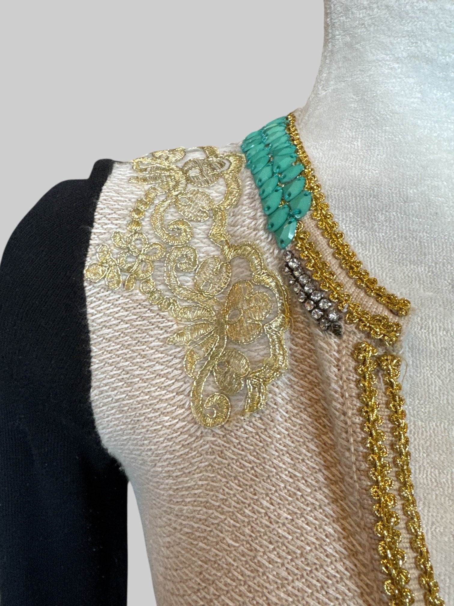 S cream cardigan with black sleeves, gold details, beads, and faux pockets