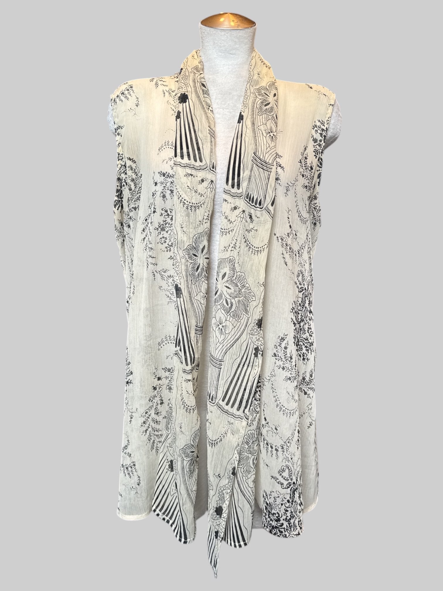 1X cream sleeveless cardigan with black floral design