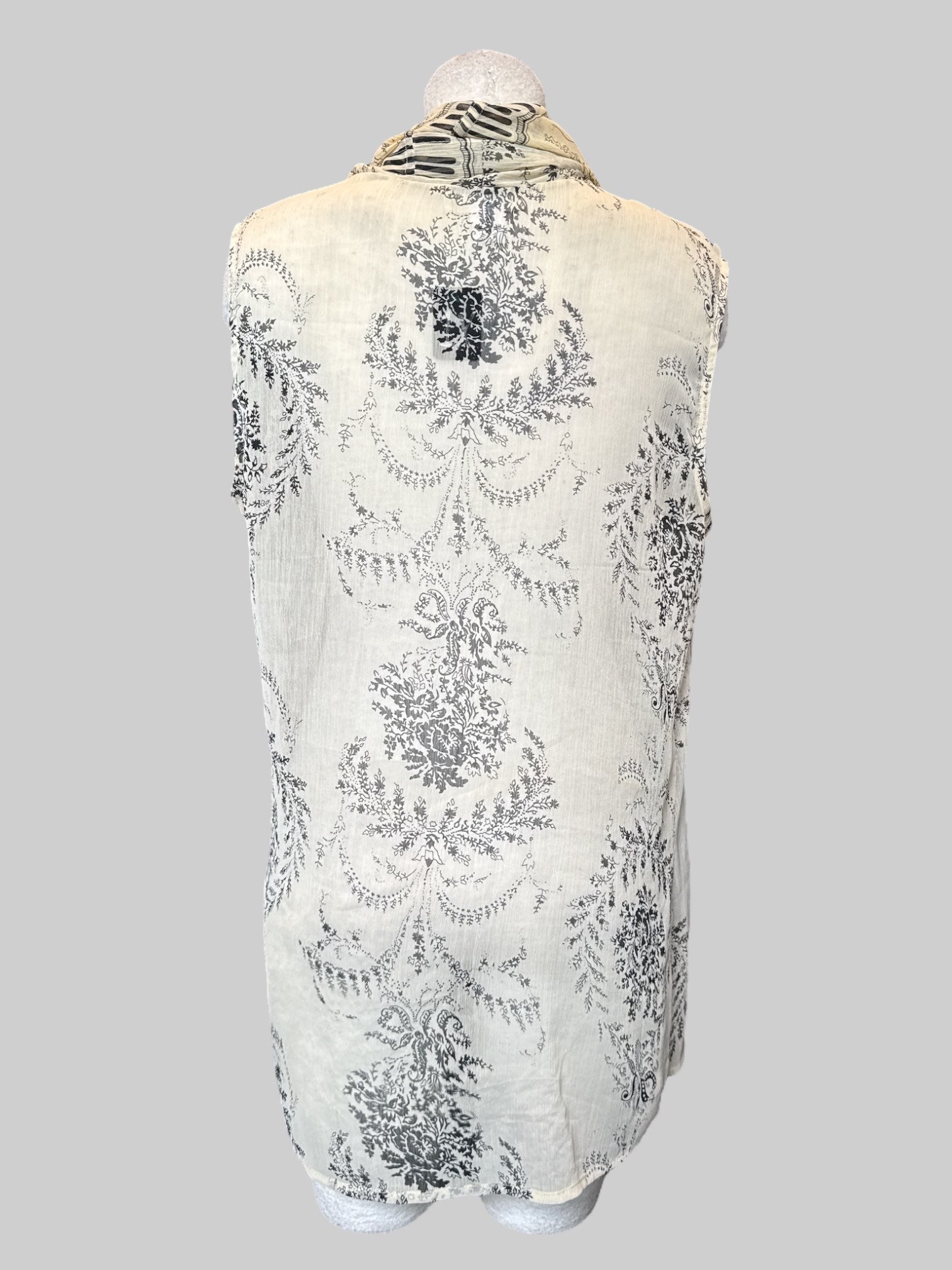 1X cream sleeveless cardigan with black floral design