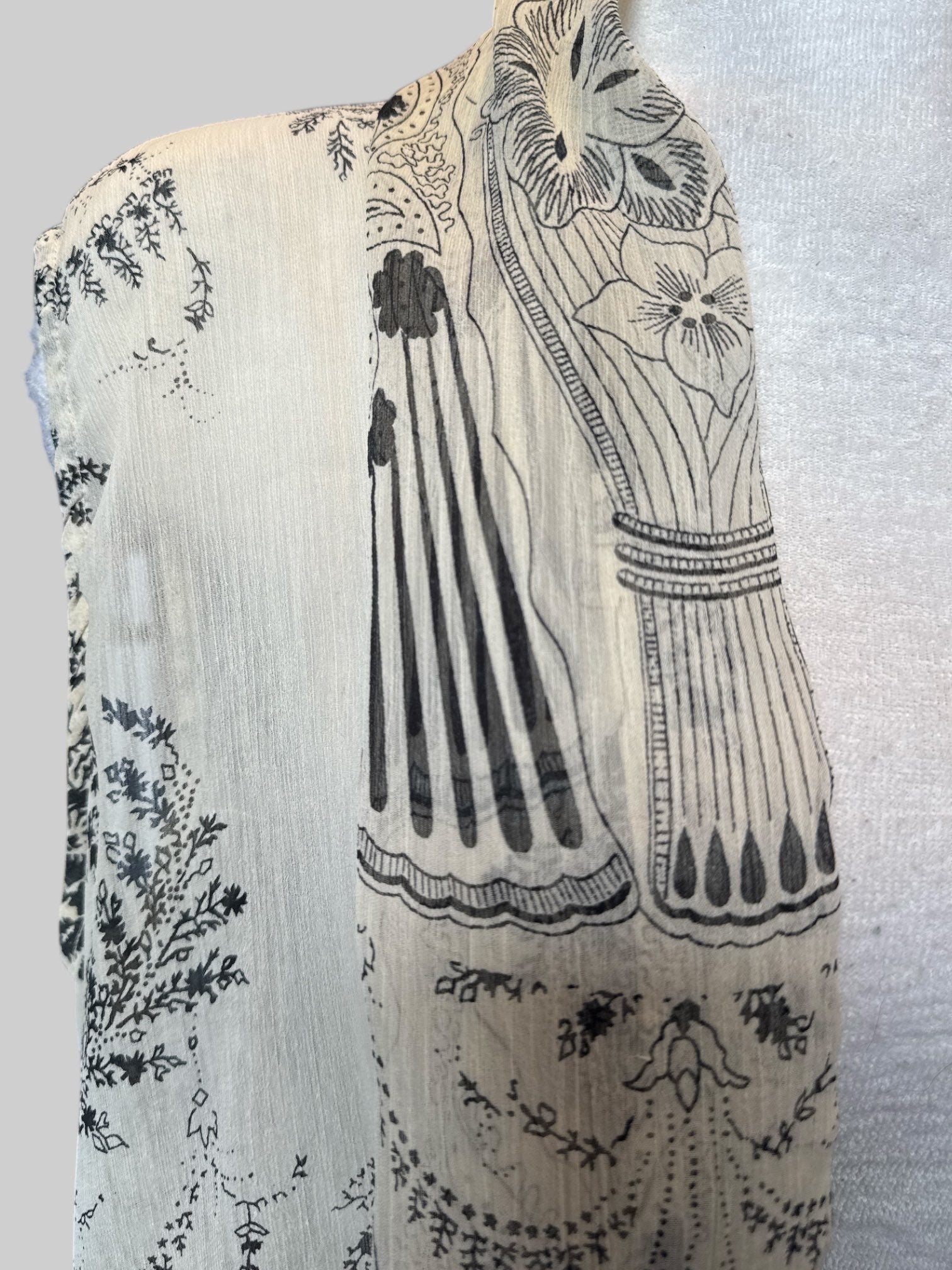 1X cream sleeveless cardigan with black floral design