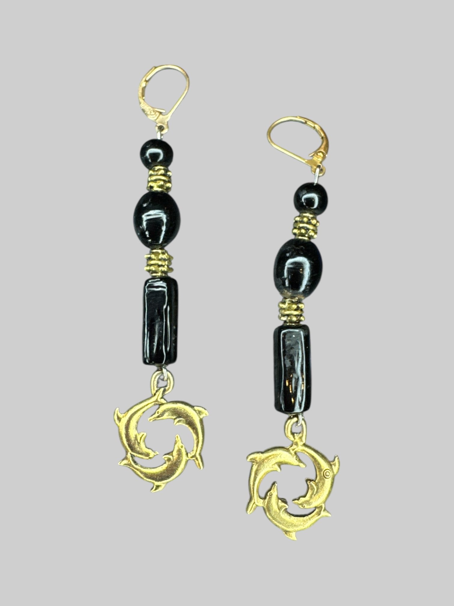 Gold tone and black beard dangle earring with dolphin charm