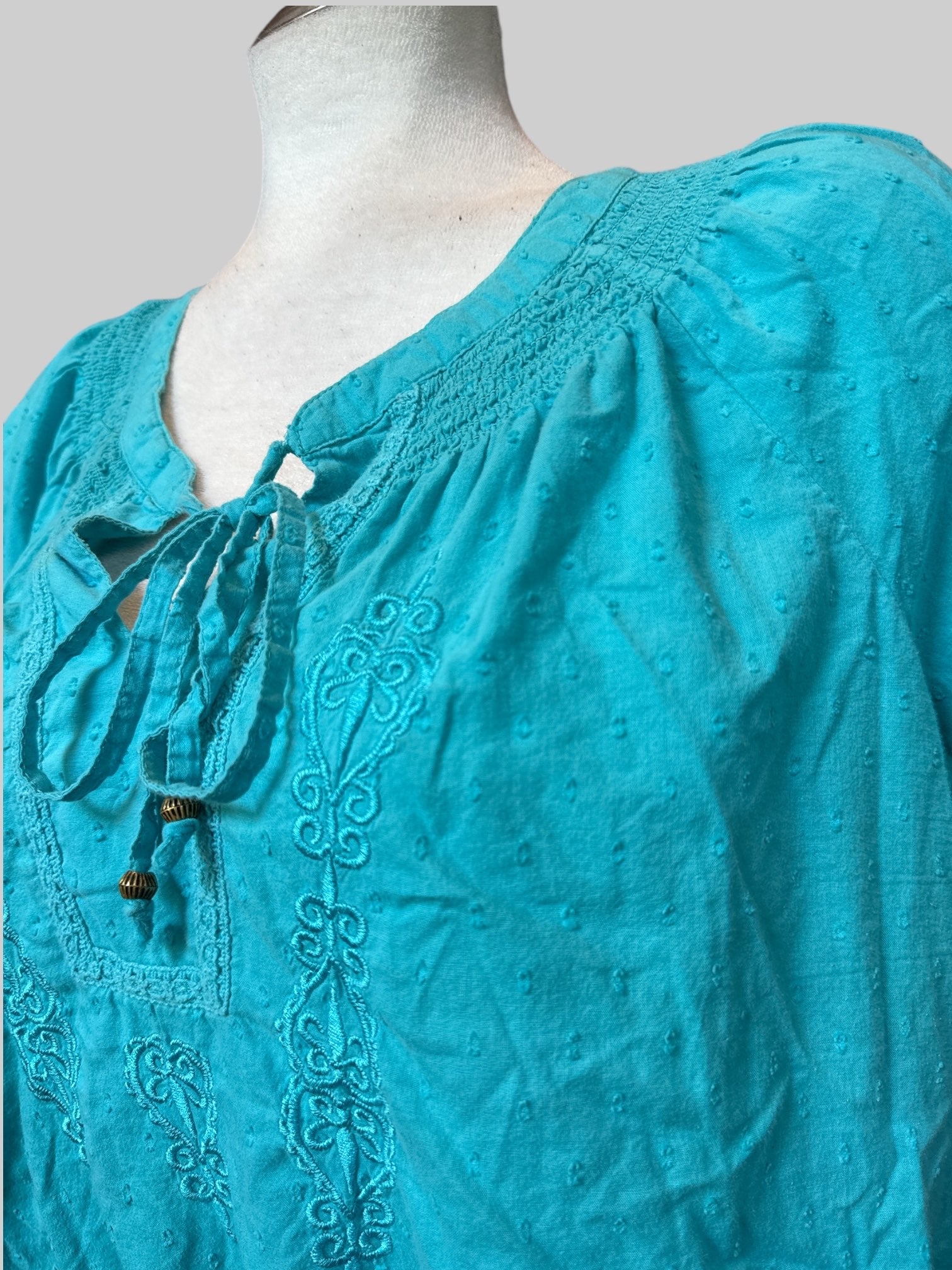 L blue top with textured polka dots, embroidery, and balloon sleeves and waist