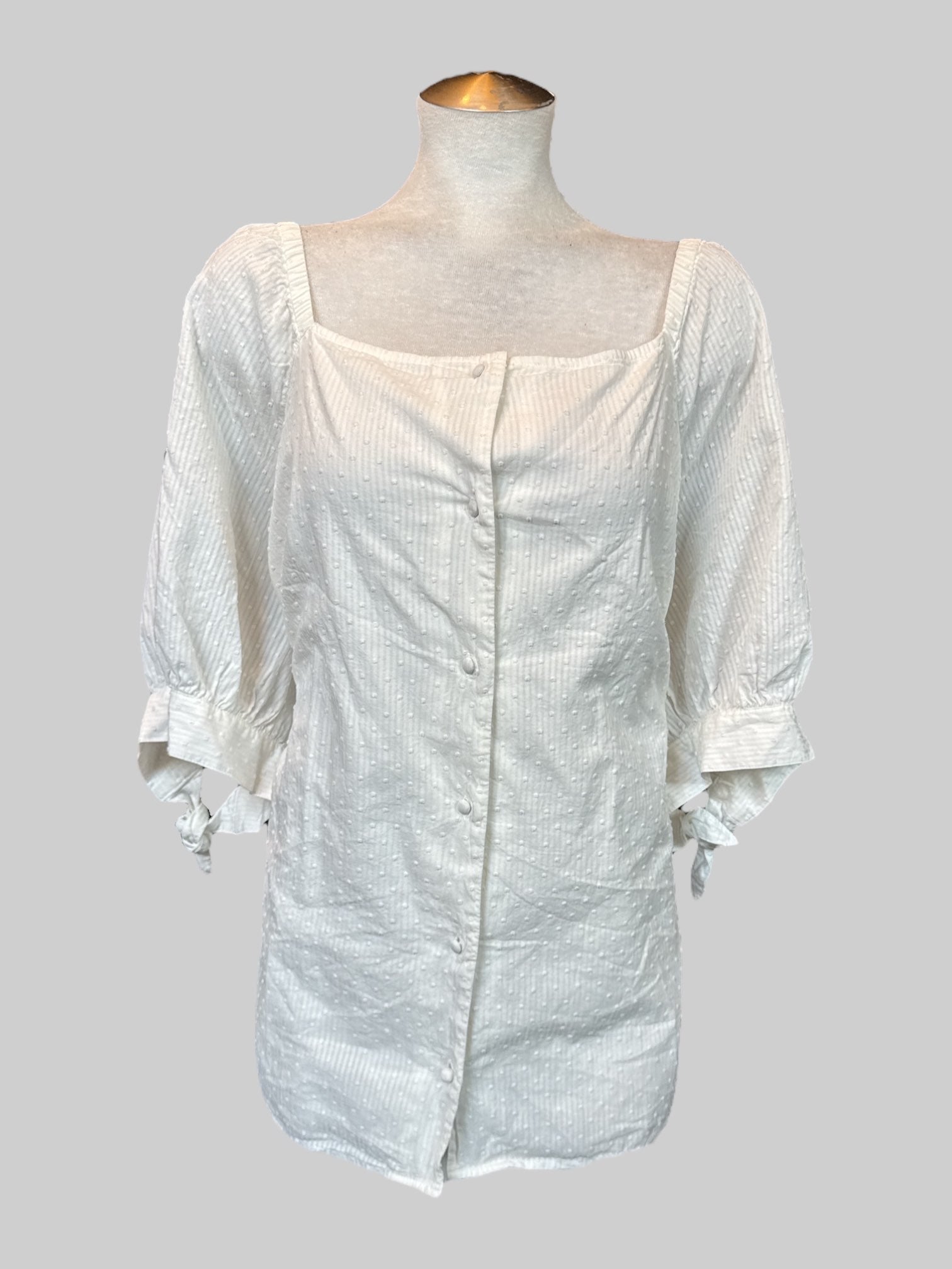 5X white top with textured dots, buttons, and tie sleeves