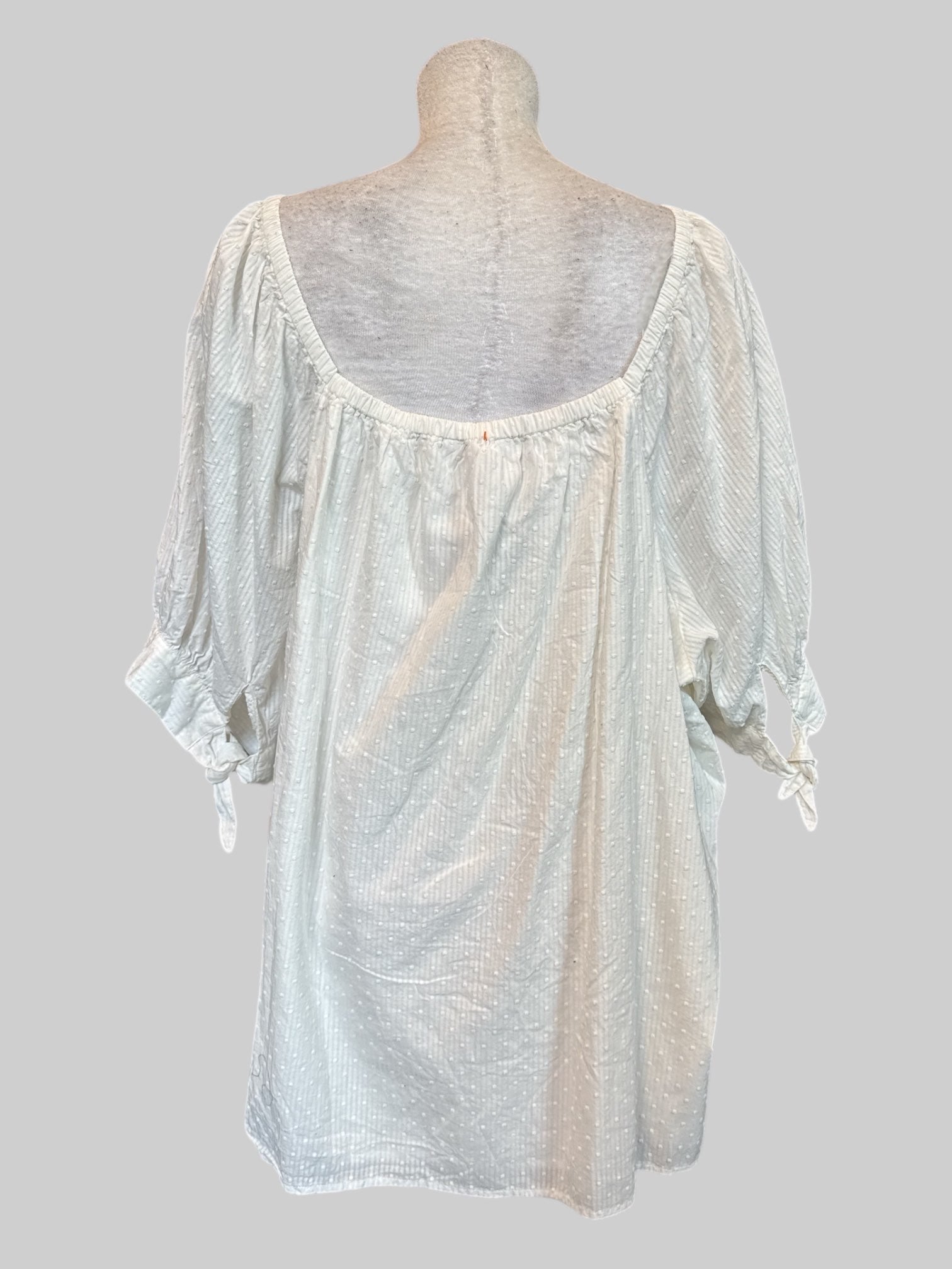 5X white top with textured dots, buttons, and tie sleeves