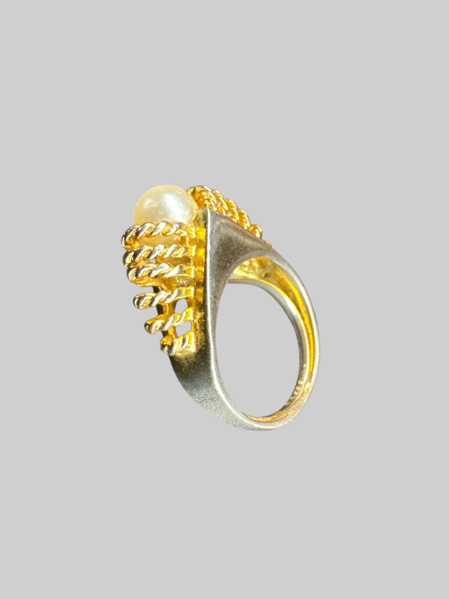 Silver tone ring with gold twisted design and pearl in middle