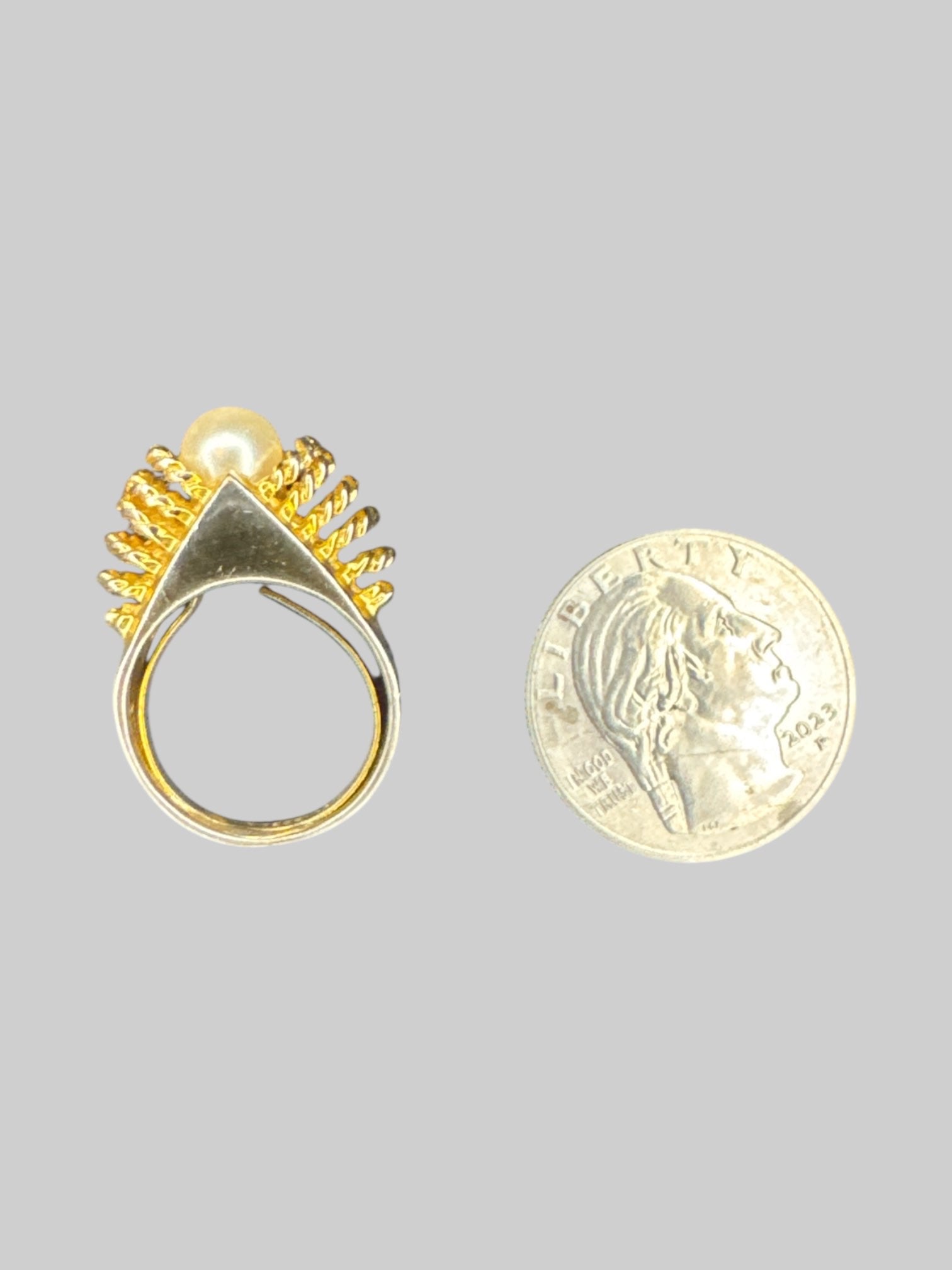 Silver tone ring with gold twisted design and pearl in middle