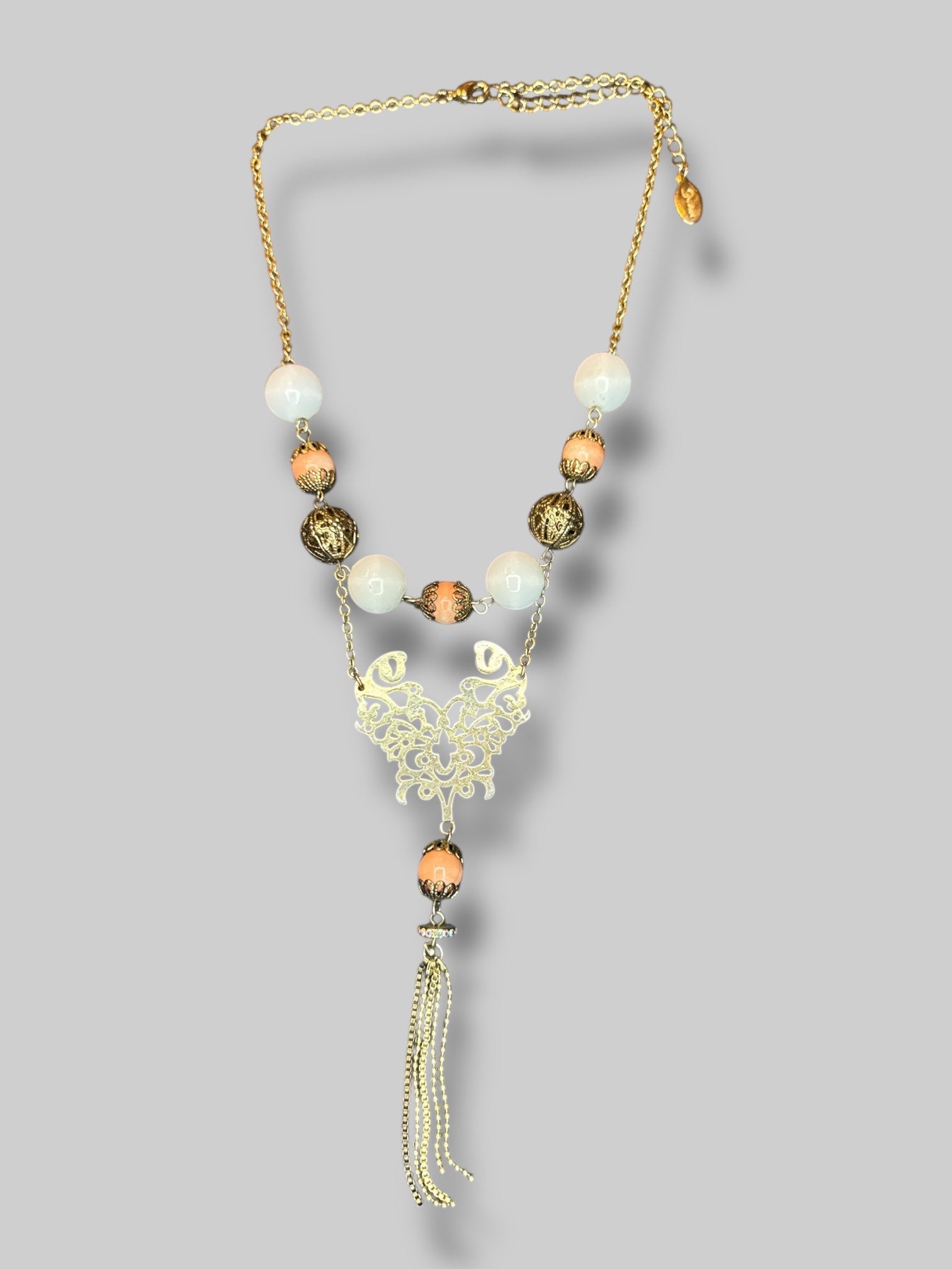 Brass tone ornate beaded necklace with tassels