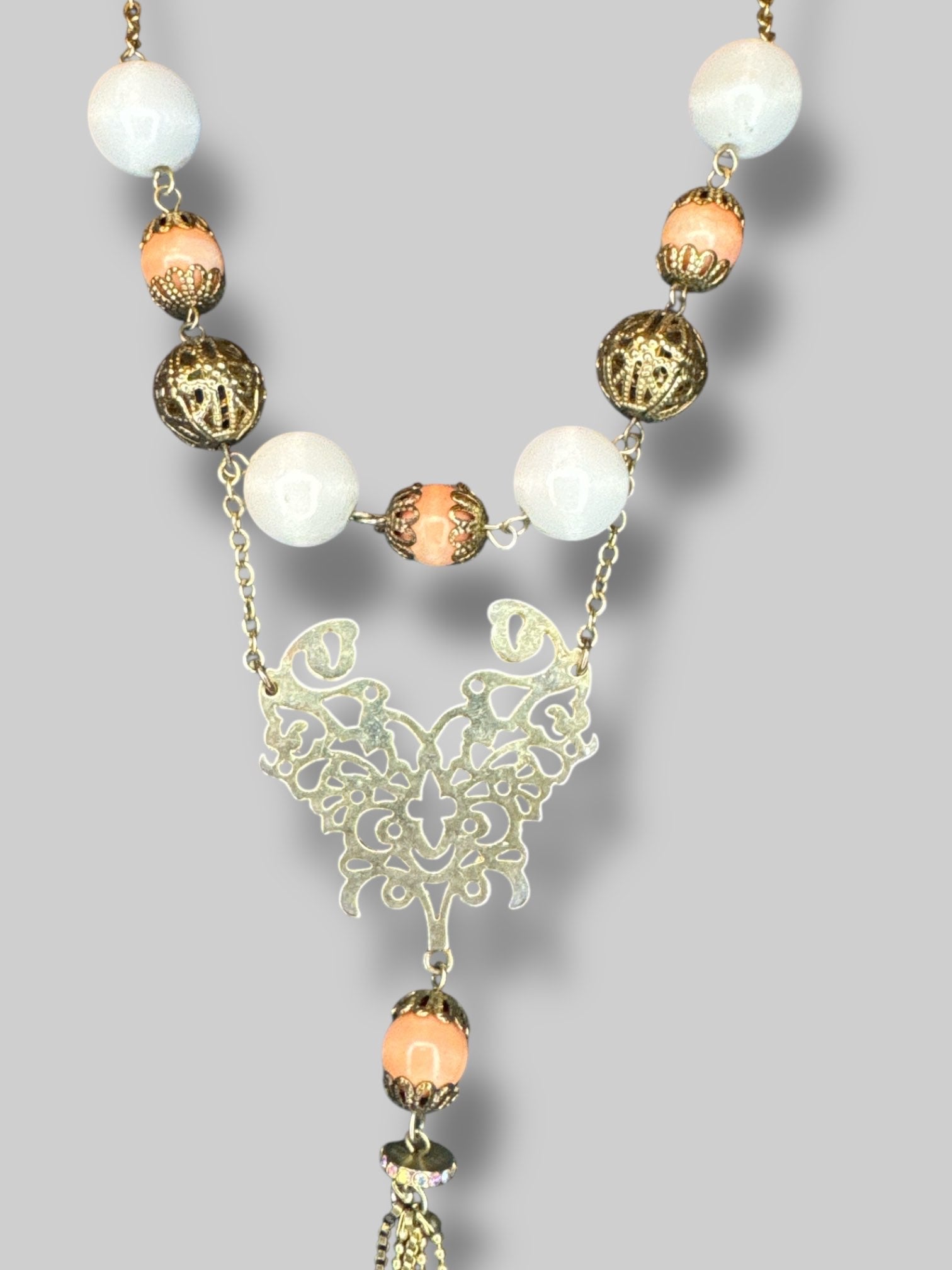Brass tone ornate beaded necklace with tassels