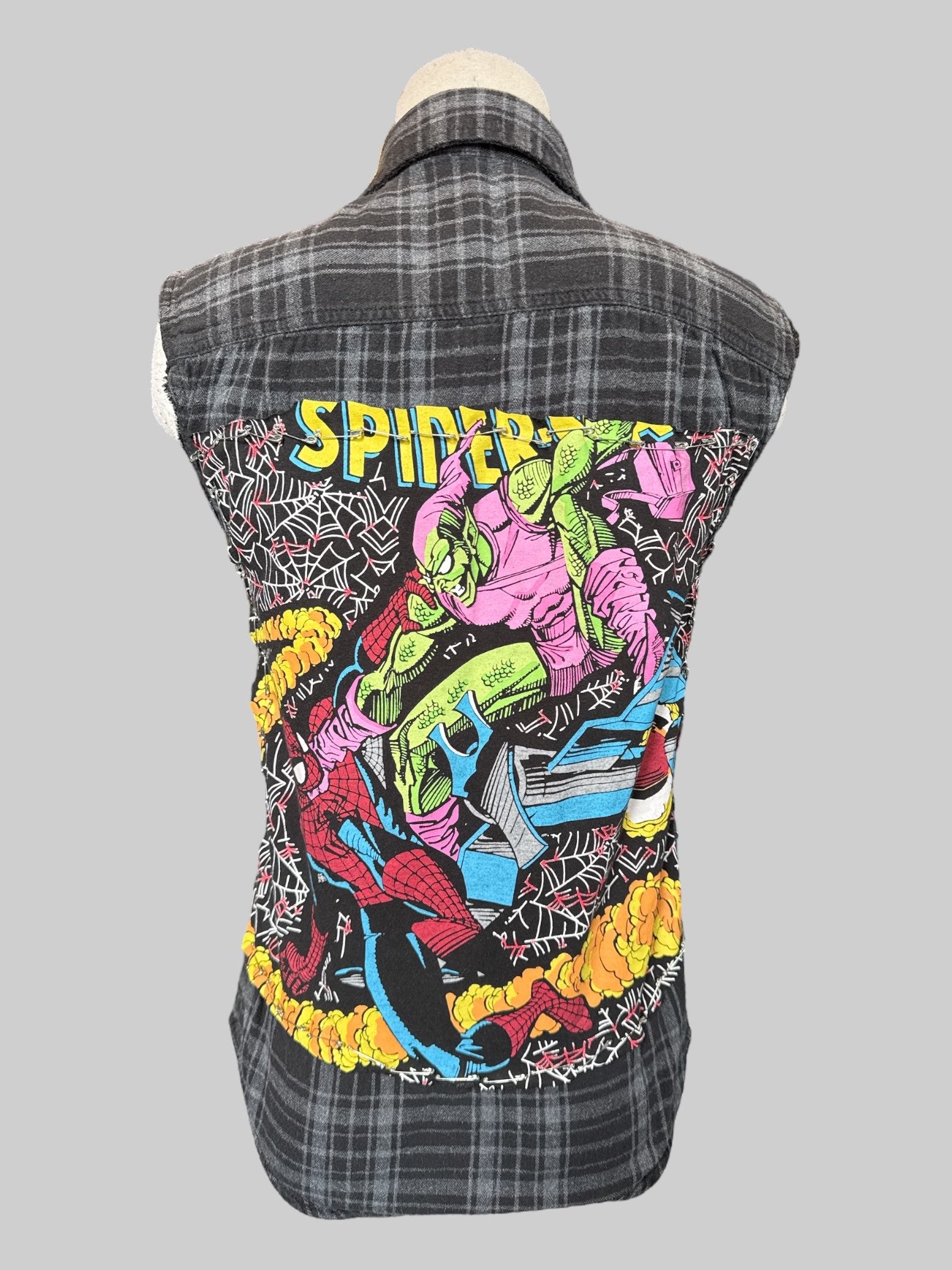 S Black flannel with cut off sleeves and hand cut Spider-Man patch on back with safety pins