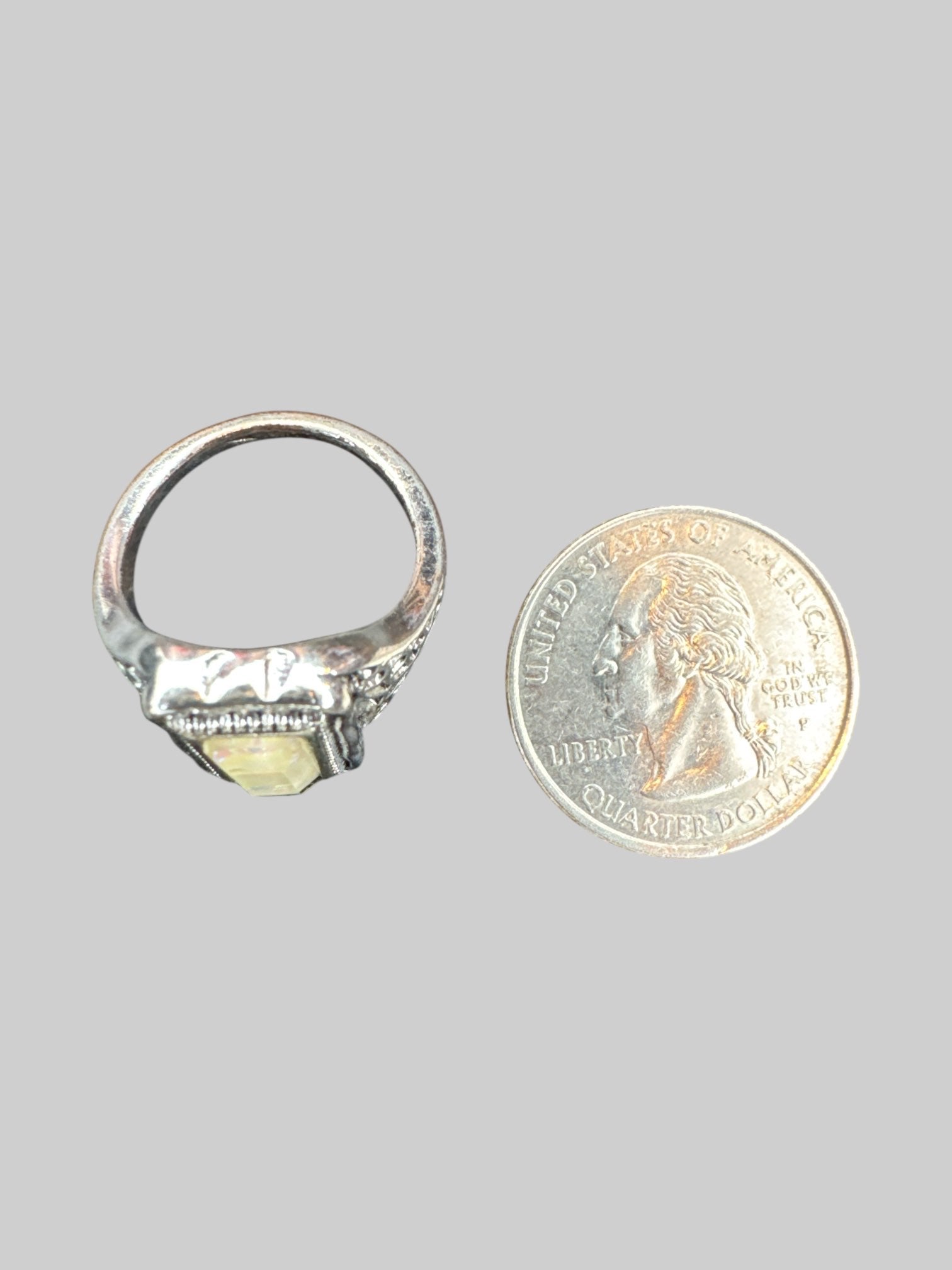 Size 7.5 Silver colored ring with designs on side with iridescent stone
