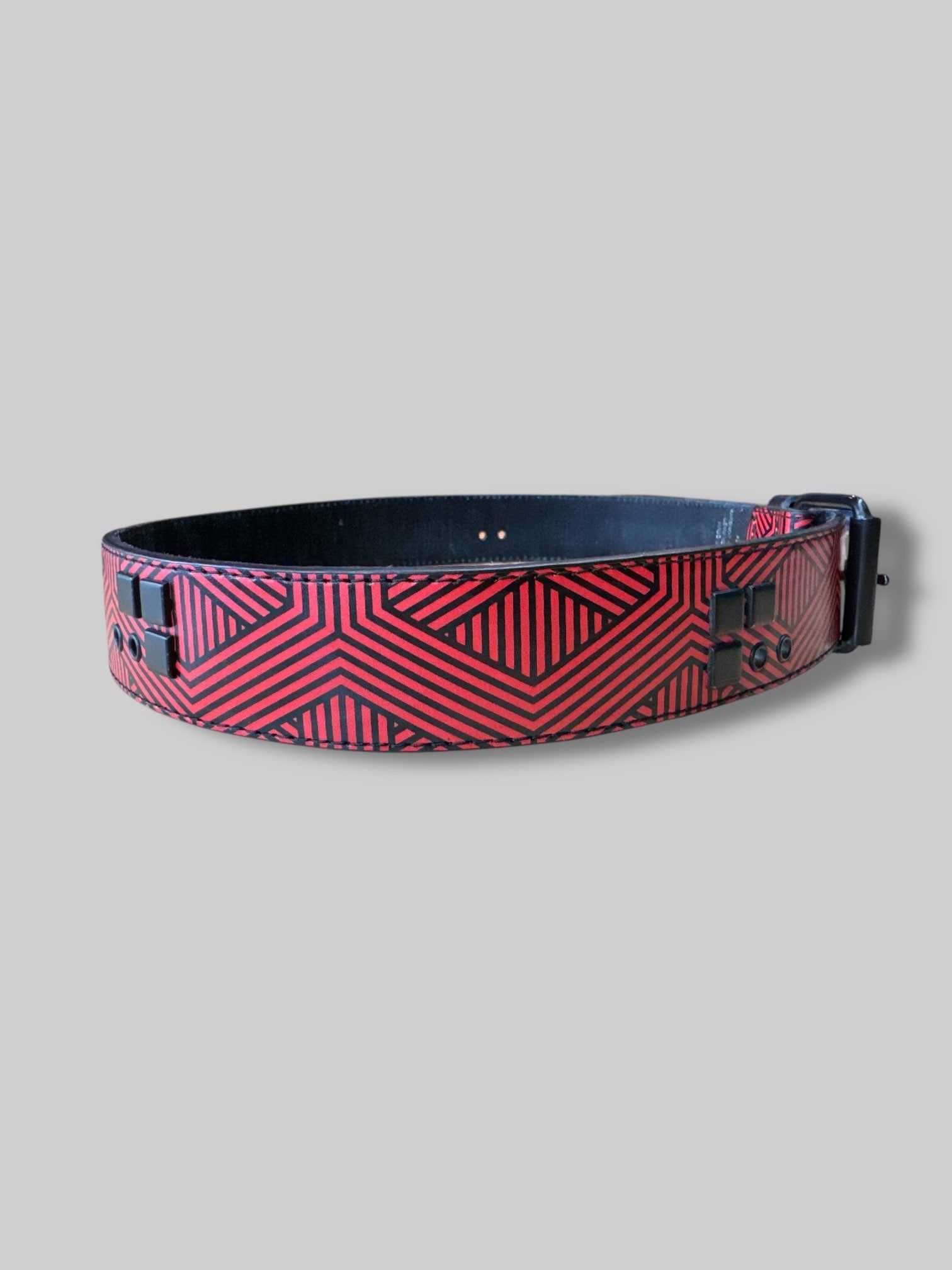 L red and black geometric belt with black studs