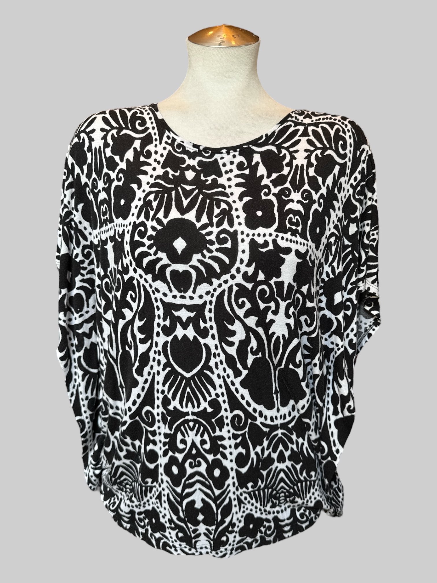 M White flowy top with black botanical prints and poncho style short sleeves