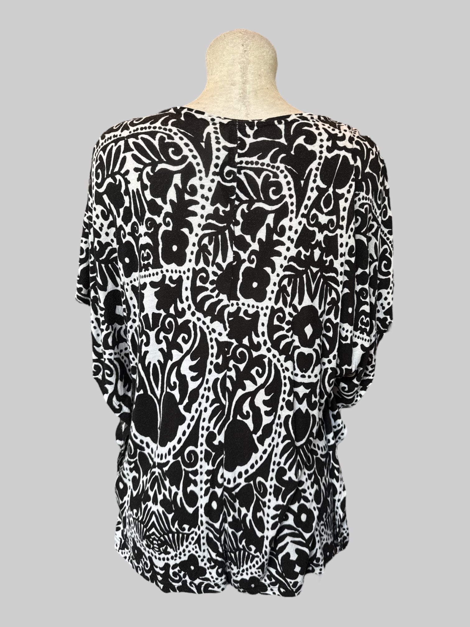 M White flowy top with black botanical prints and poncho style short sleeves
